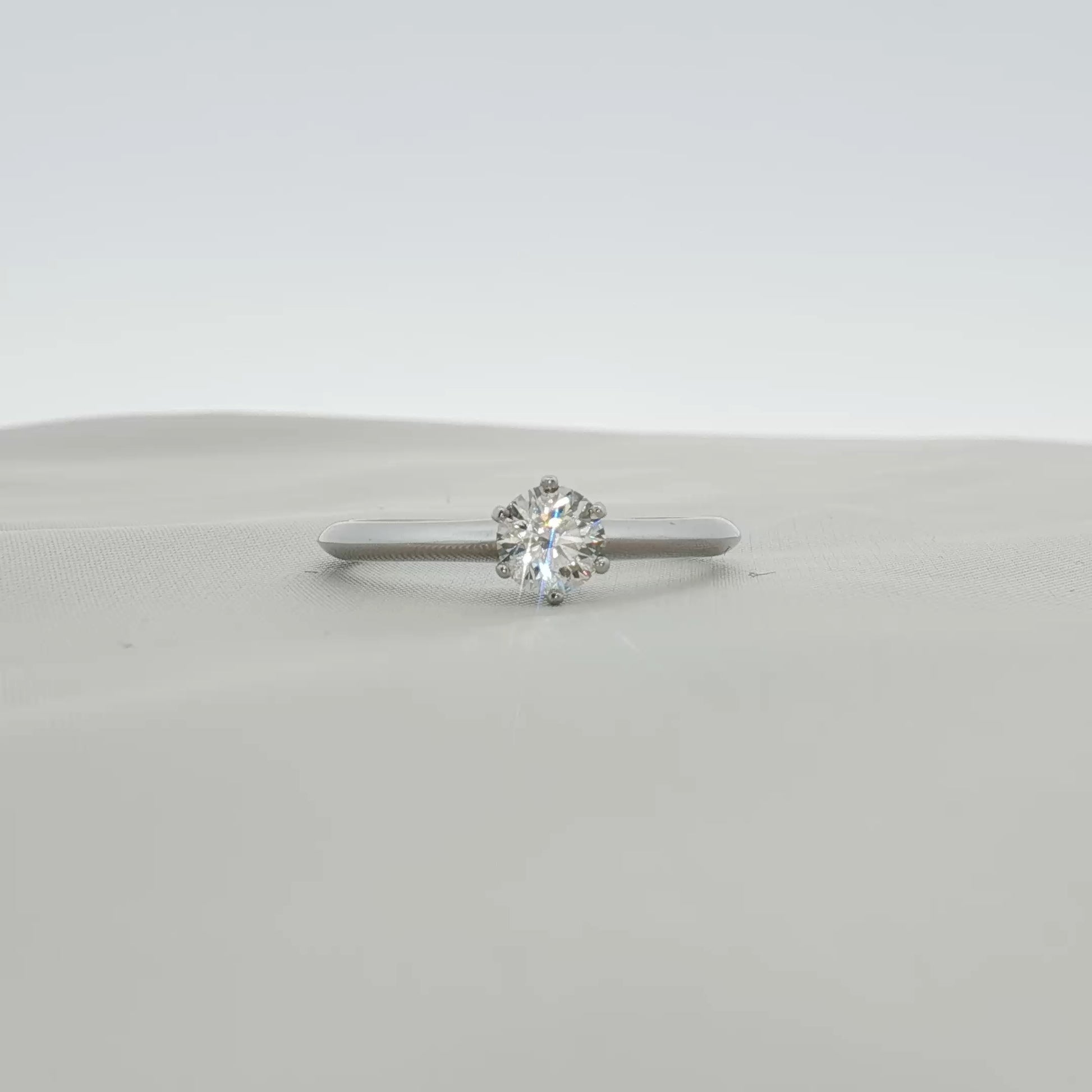 Platinum solitaire engagement ring from Tiffany & Co. featuring a central diamond set in a sleek, elegant jewelry design.