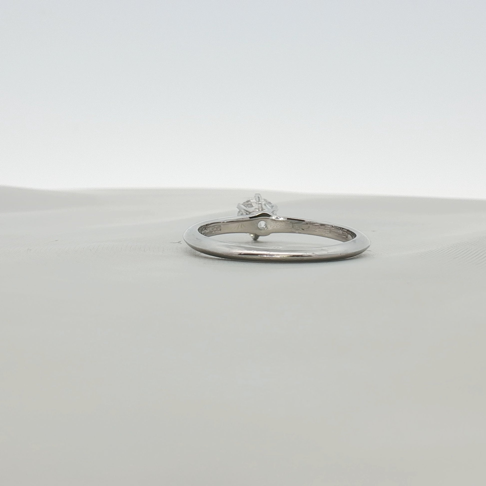 Platinum solitaire engagement ring by Gold & Beyond featuring a single sparkling diamond set in a sleek band.
