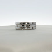 Cartier Maillon Band ring in gold, featuring a linked chain design, displayed on a jewelry stand.