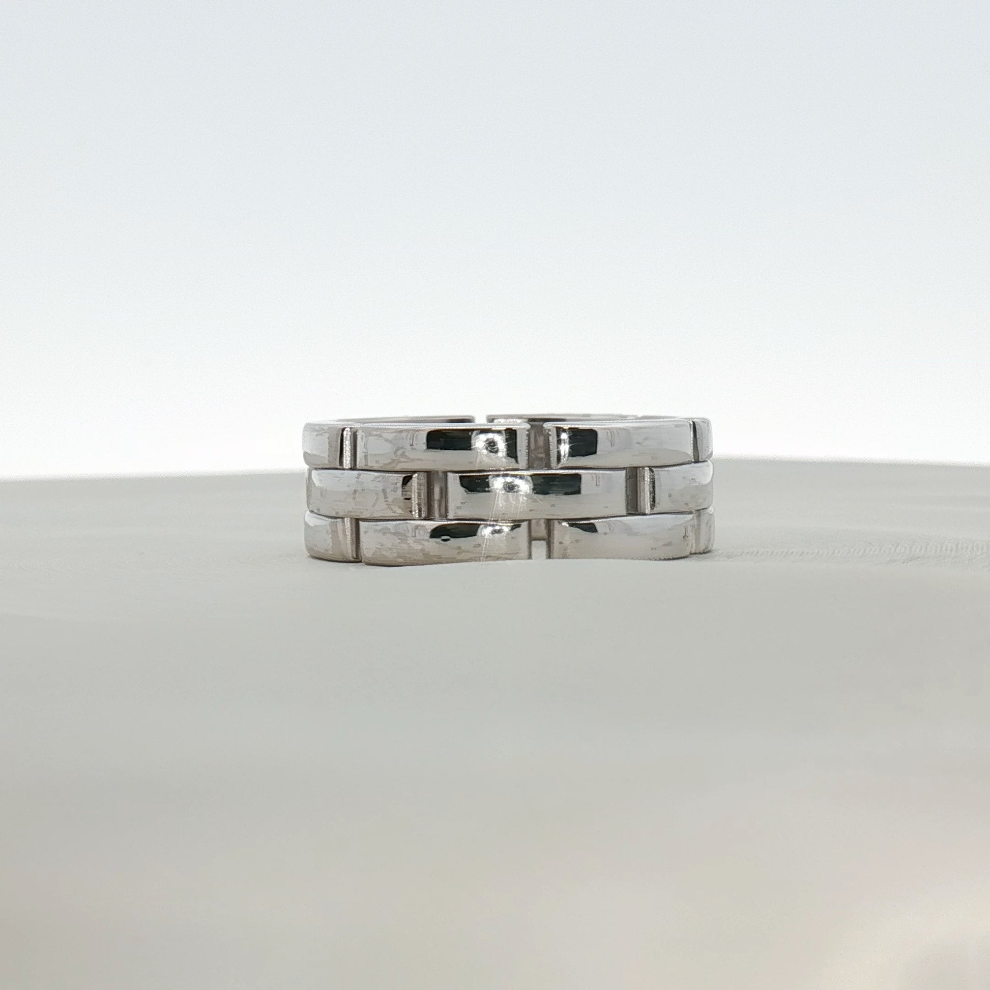 Cartier Maillon Band ring in gold jewelry displayed on a neutral background, showcasing its linked chain design and craftsmanship.
