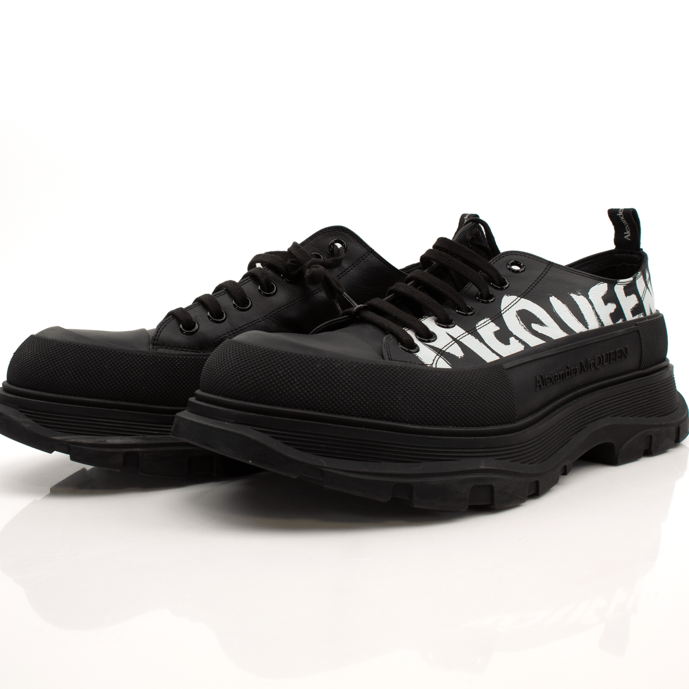 Alexander McQueen oversized sneakers in white with chunky soles and gold accents, styled as fashionable casual shoes.