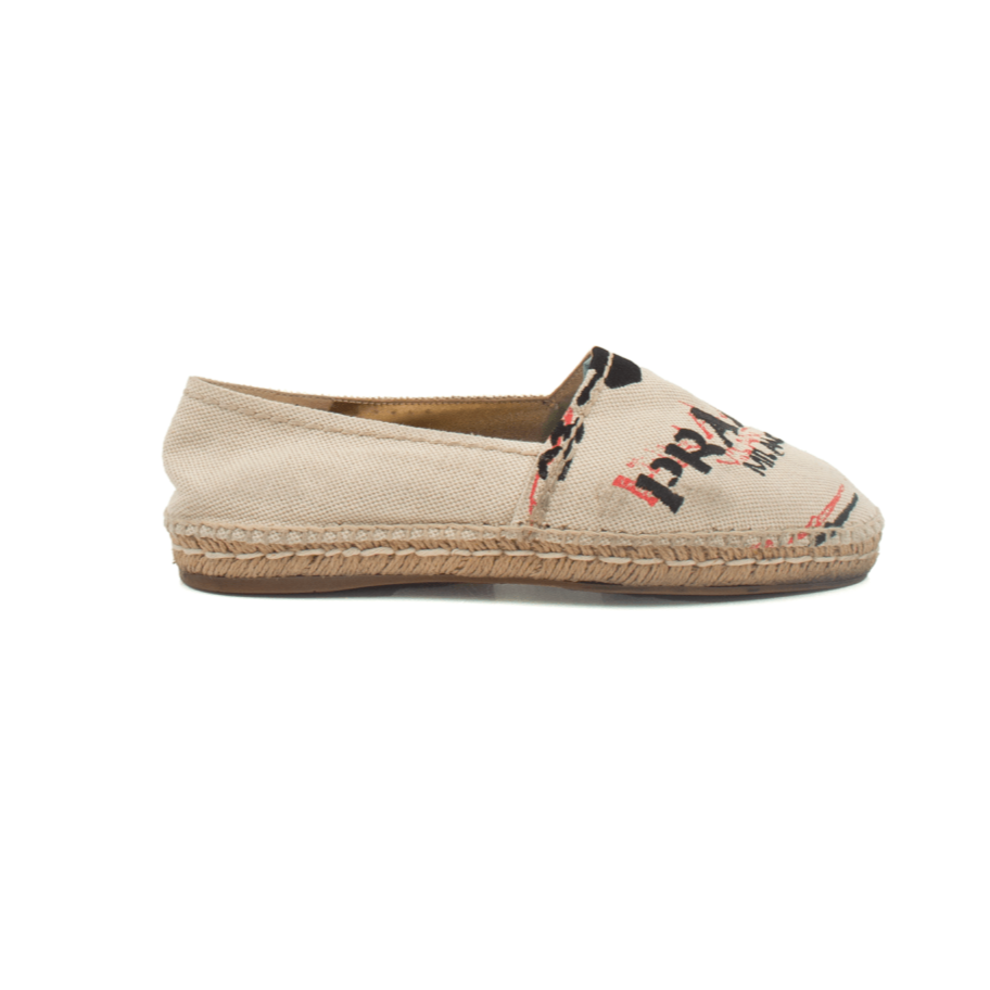 Prada canvas espadrille shoes with beige and black design, featuring woven jute soles and casual slip-on style.