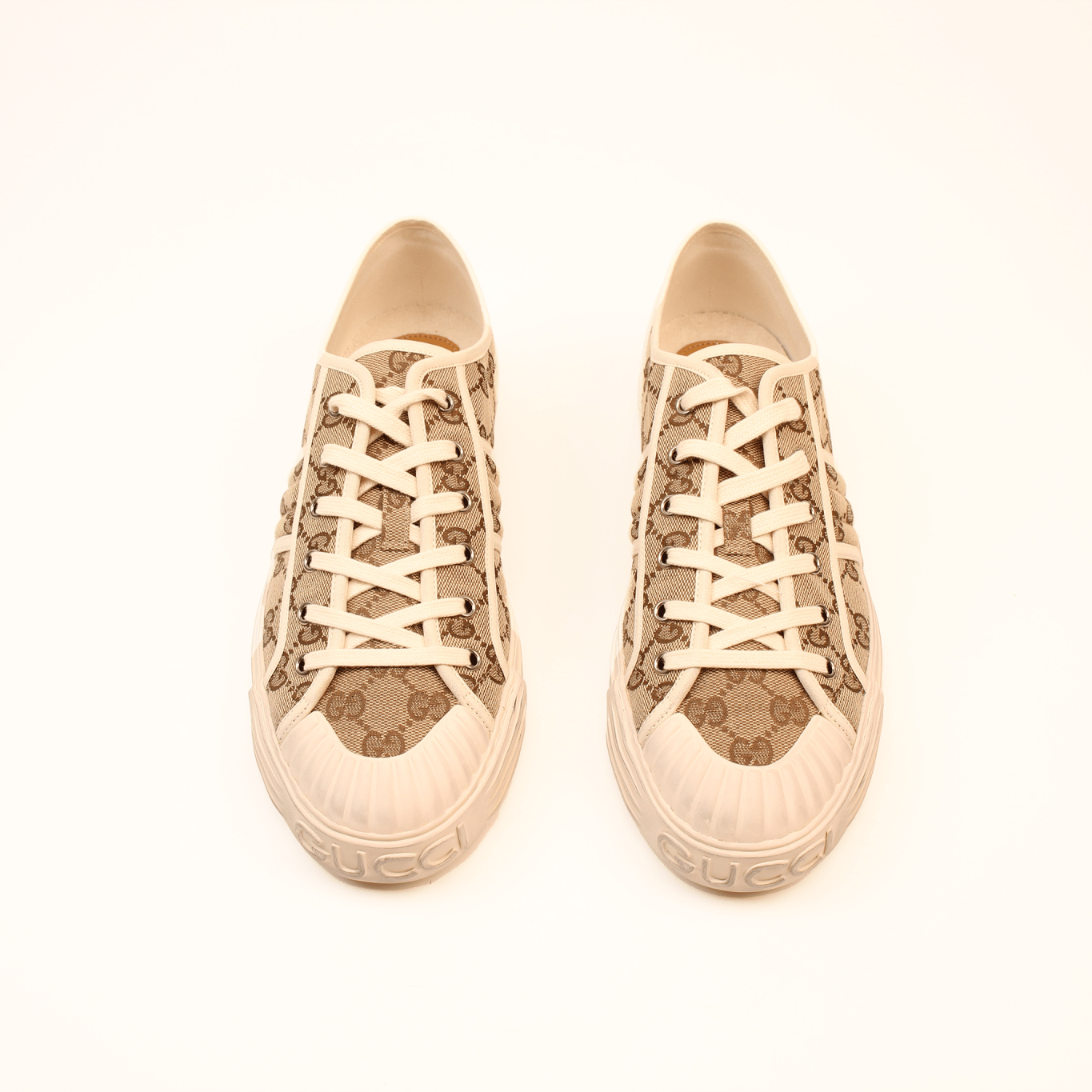 Gold & Beyond Gucci GG Supreme sneakers featuring classic design, white soles, and signature monogram pattern on stylish shoes.
