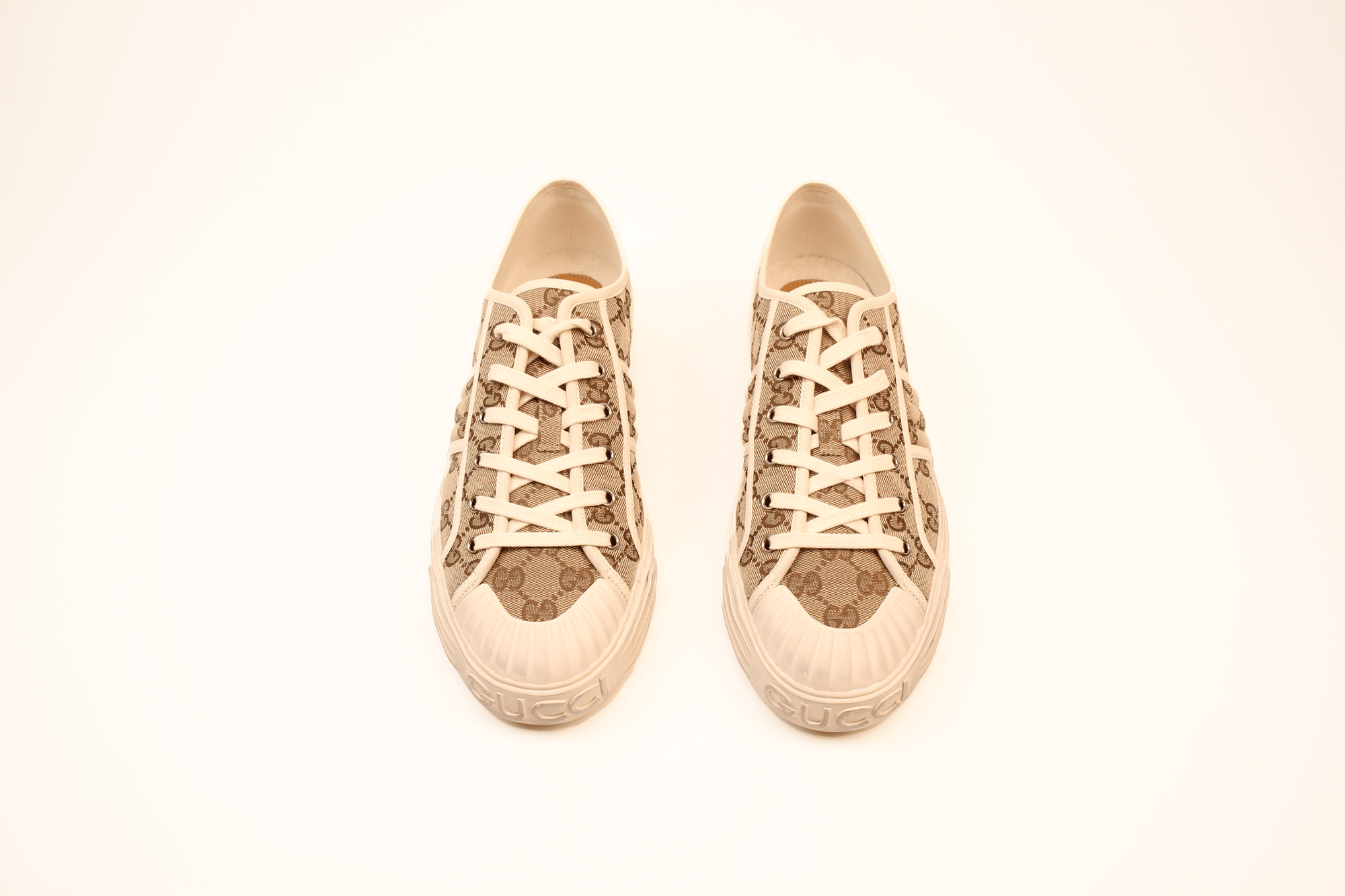 Gold & Beyond Gucci GG Supreme sneakers with white soles and signature monogram pattern, stylish casual shoes for men.