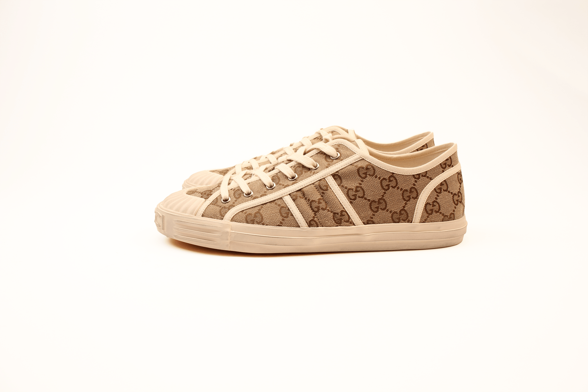 Gold & Beyond Gucci GG Supreme Sneakers, stylish shoes with iconic monogram pattern and white rubber soles, close-up view.
