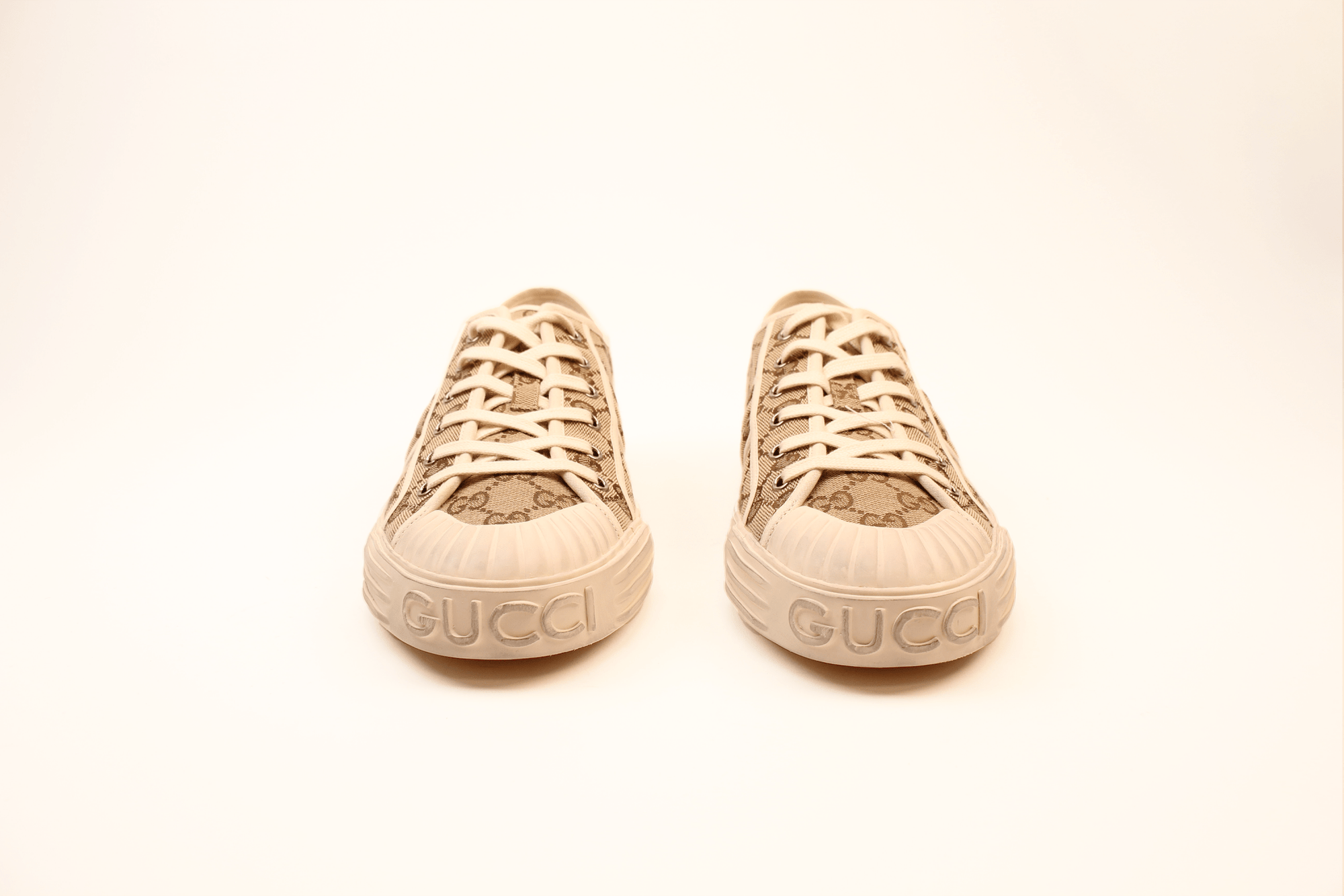 Gold & Beyond Gucci GG Supreme sneakers, stylish shoes with signature patterned canvas and white rubber soles.