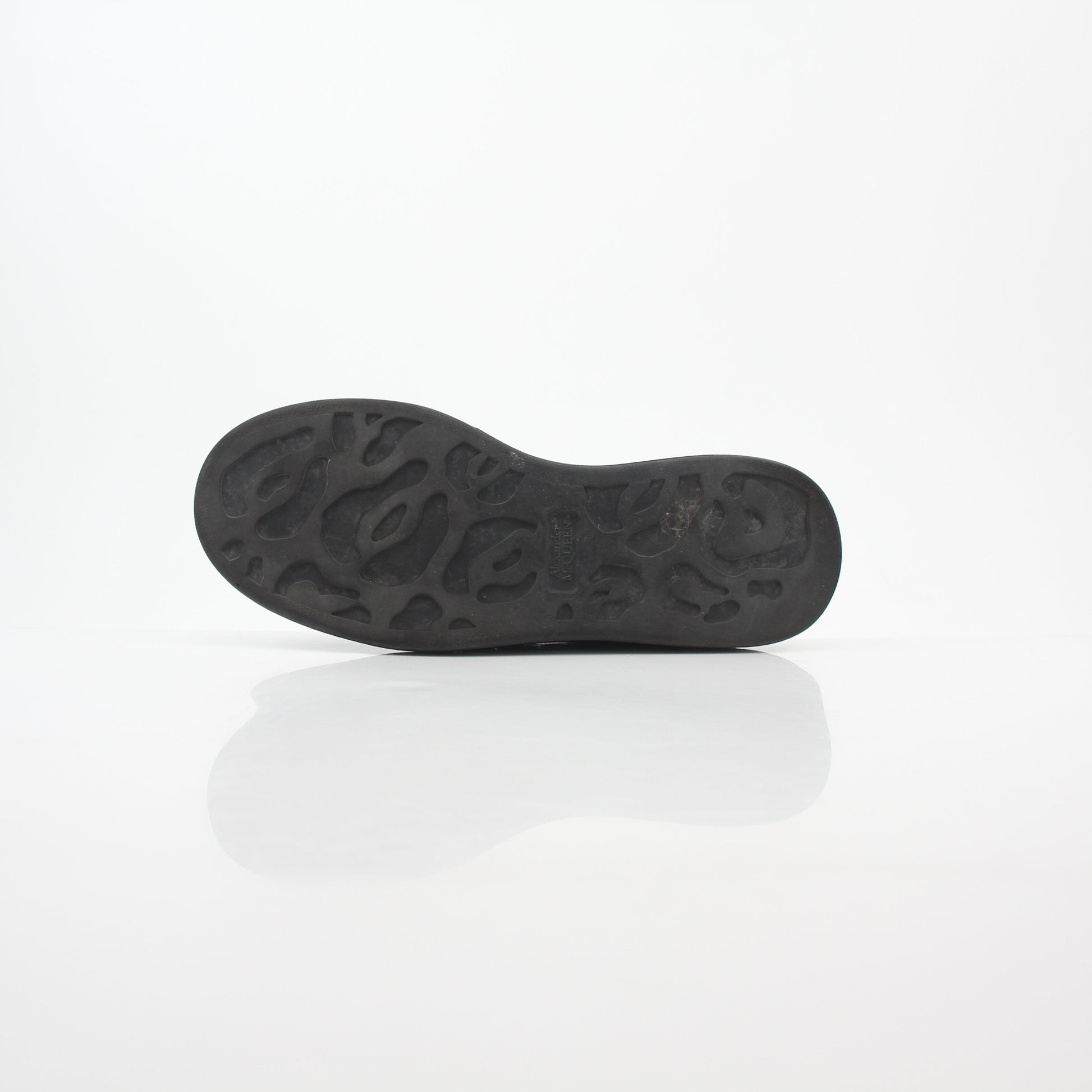 Black croc-embossed Alexander McQueen oversized sneakers with chunky design and white soles, displayed on a plain background.