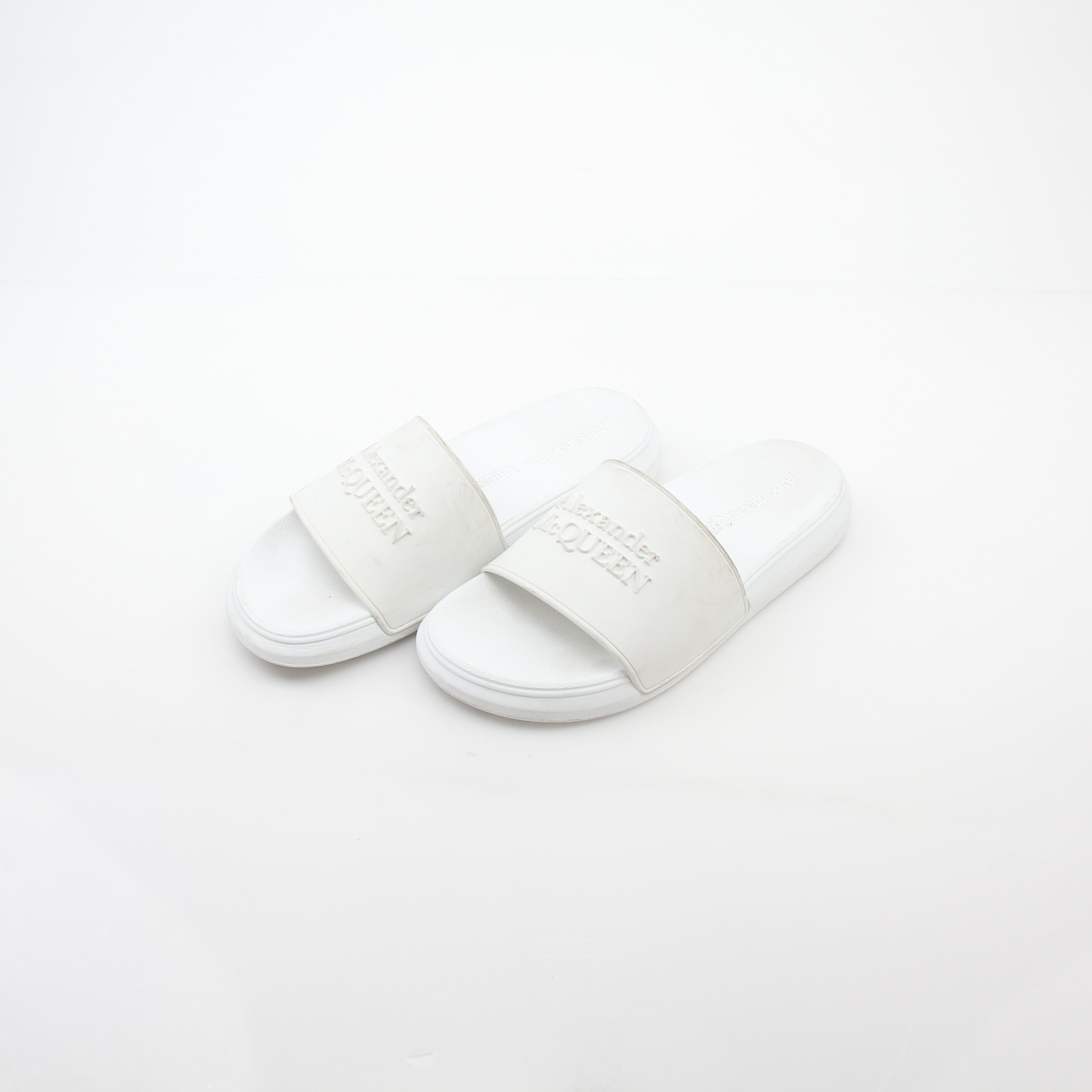 Alexander McQueen white logo pool slide sandals with open toe design and slip-on style, featuring branded straps.