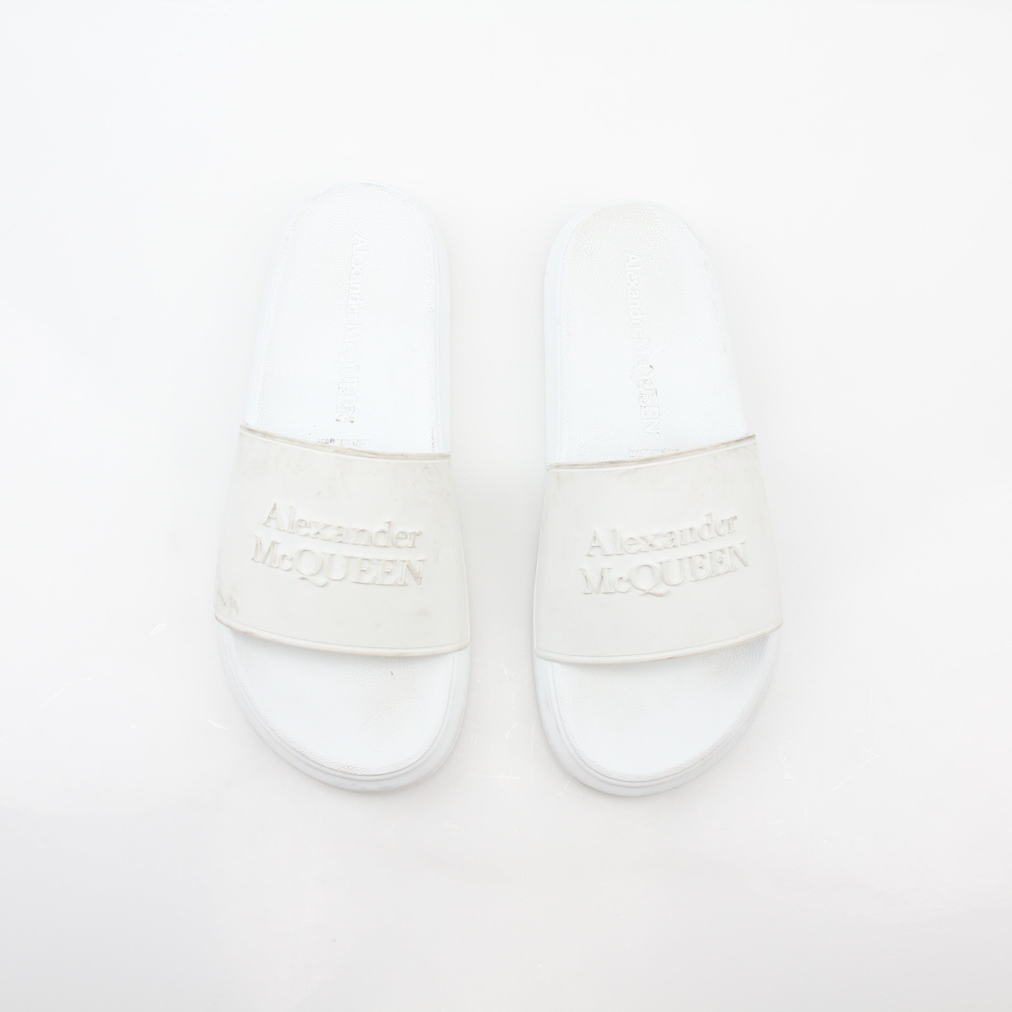 Alexander McQueen white logo pool slide sandals with open-toe design and slip-on style, featuring the brand's logo on the strap.