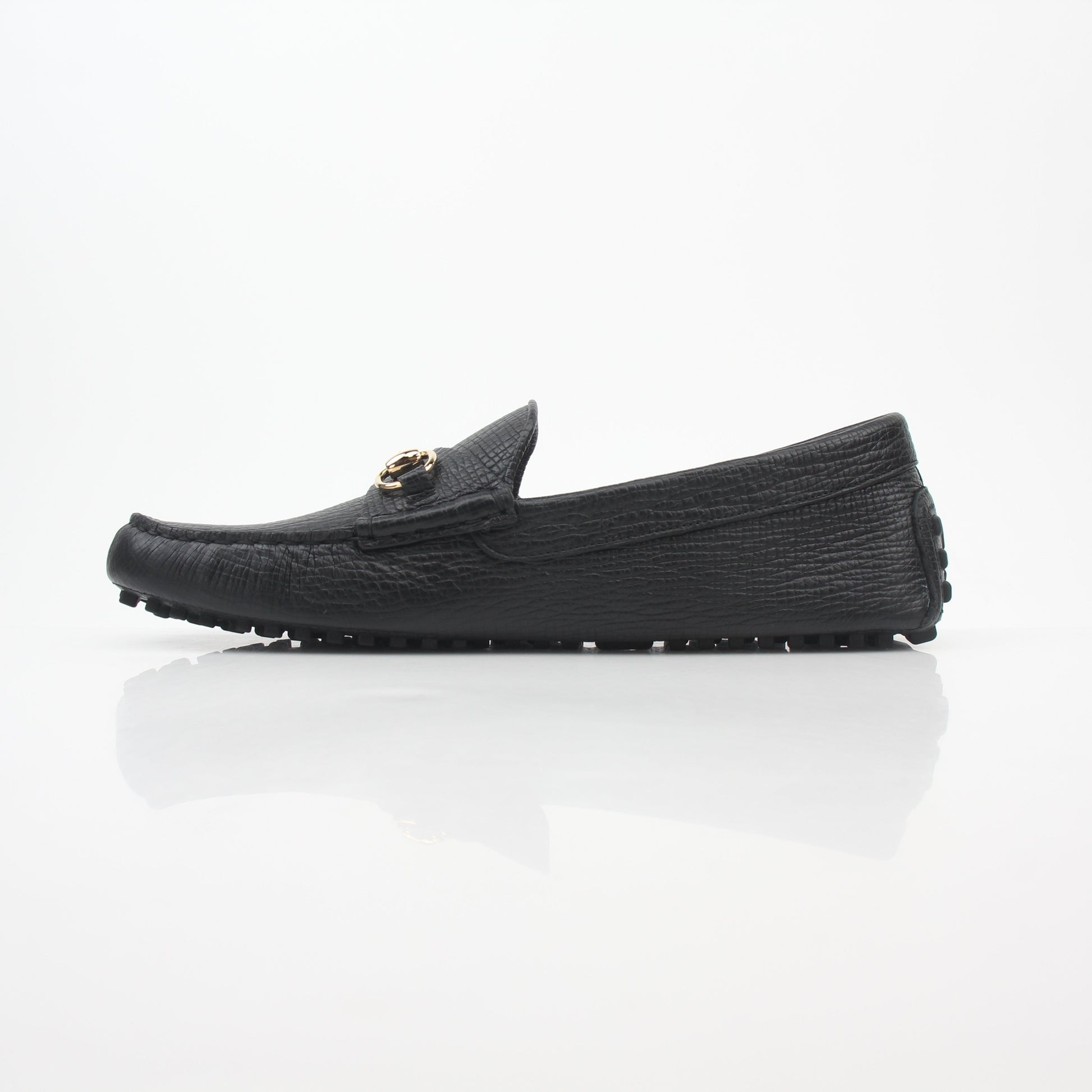 Gucci black leather Ayrton horsebit driving loafers with gold accents, stylish men's shoes, close-up view of the loafers.