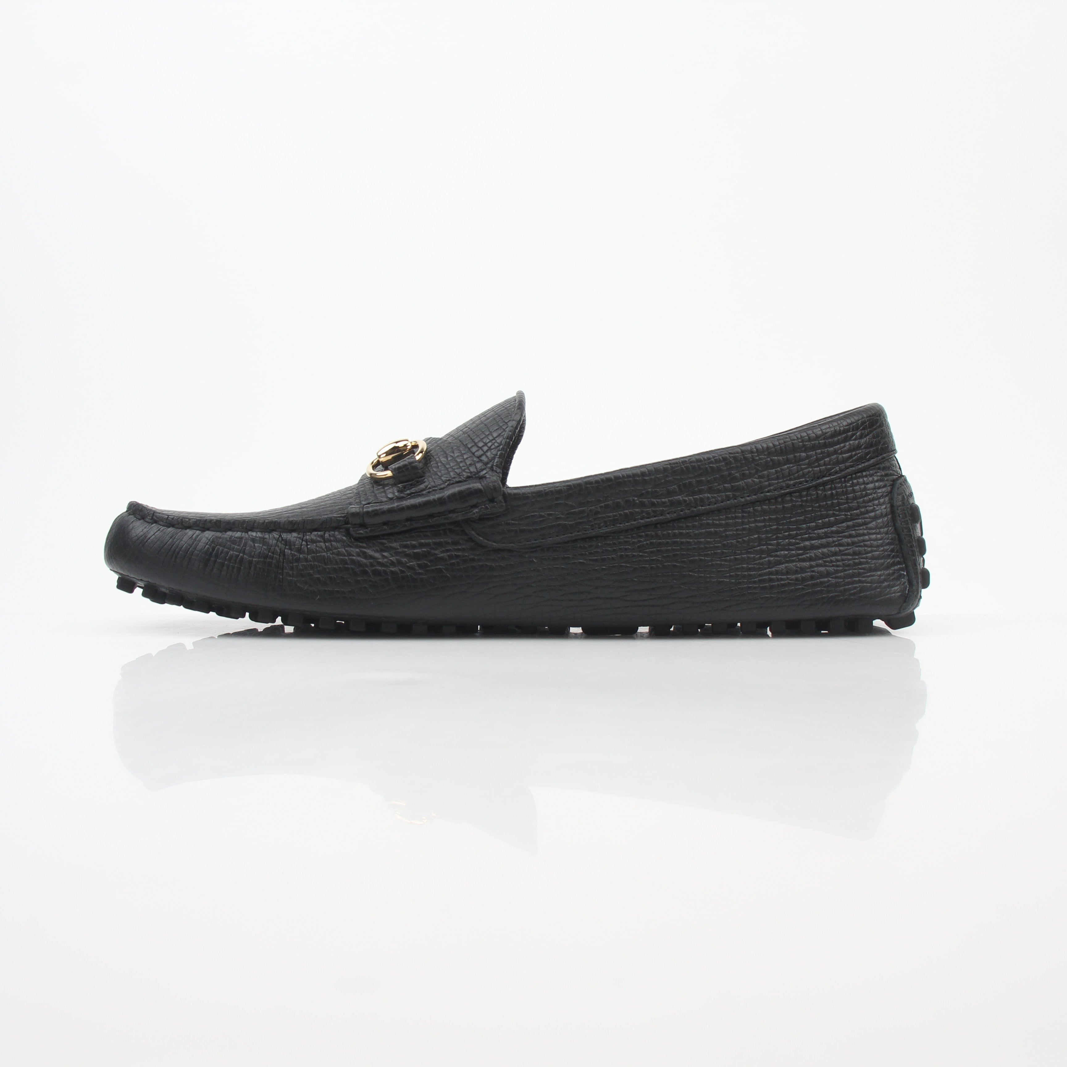 Gucci black leather Ayrton horsebit driving loafers with gold accents, stylish men's shoes, close-up view of the loafers.