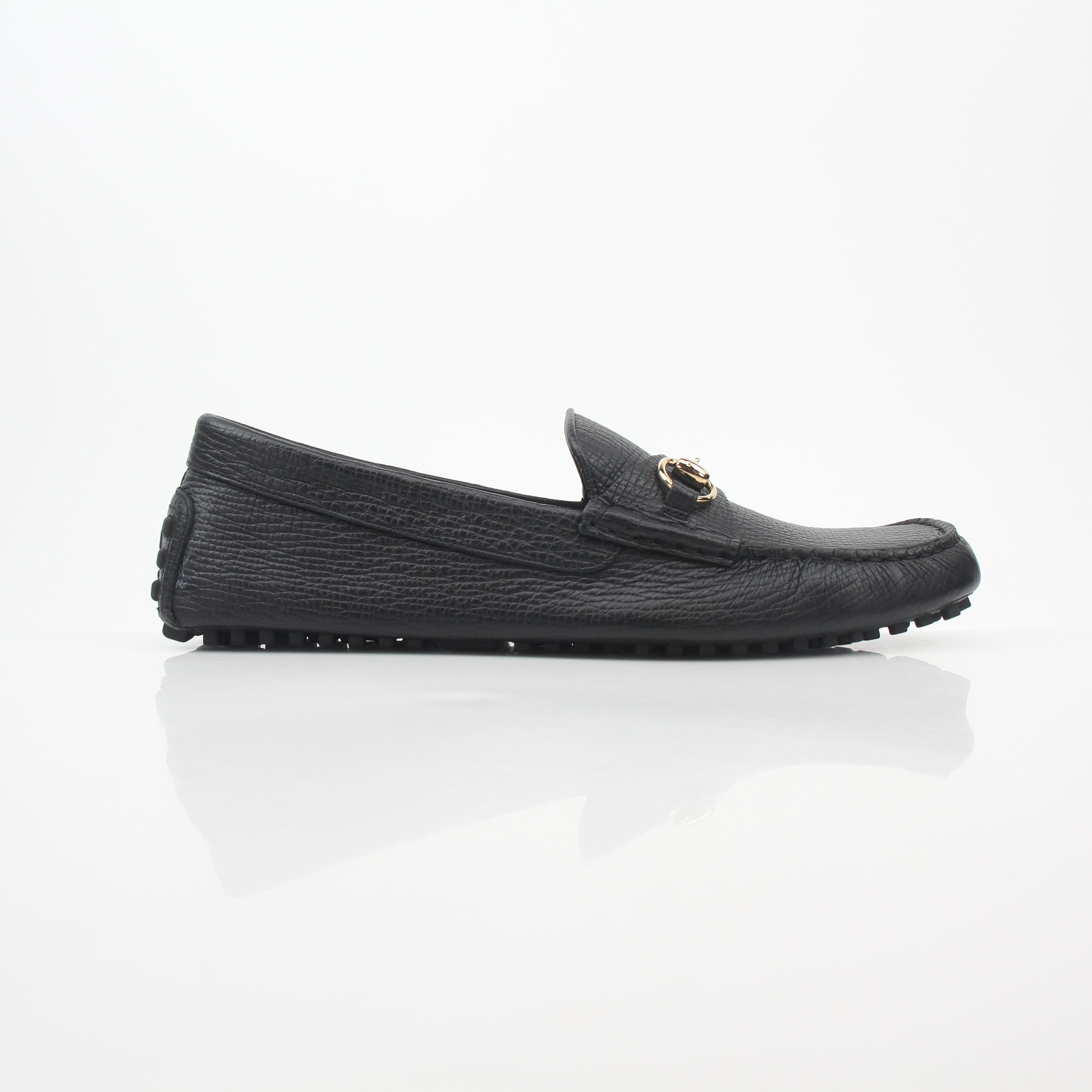 Gucci black leather Ayrton horsebit driving loafers with gold accents, stylish men's shoes on a white background.