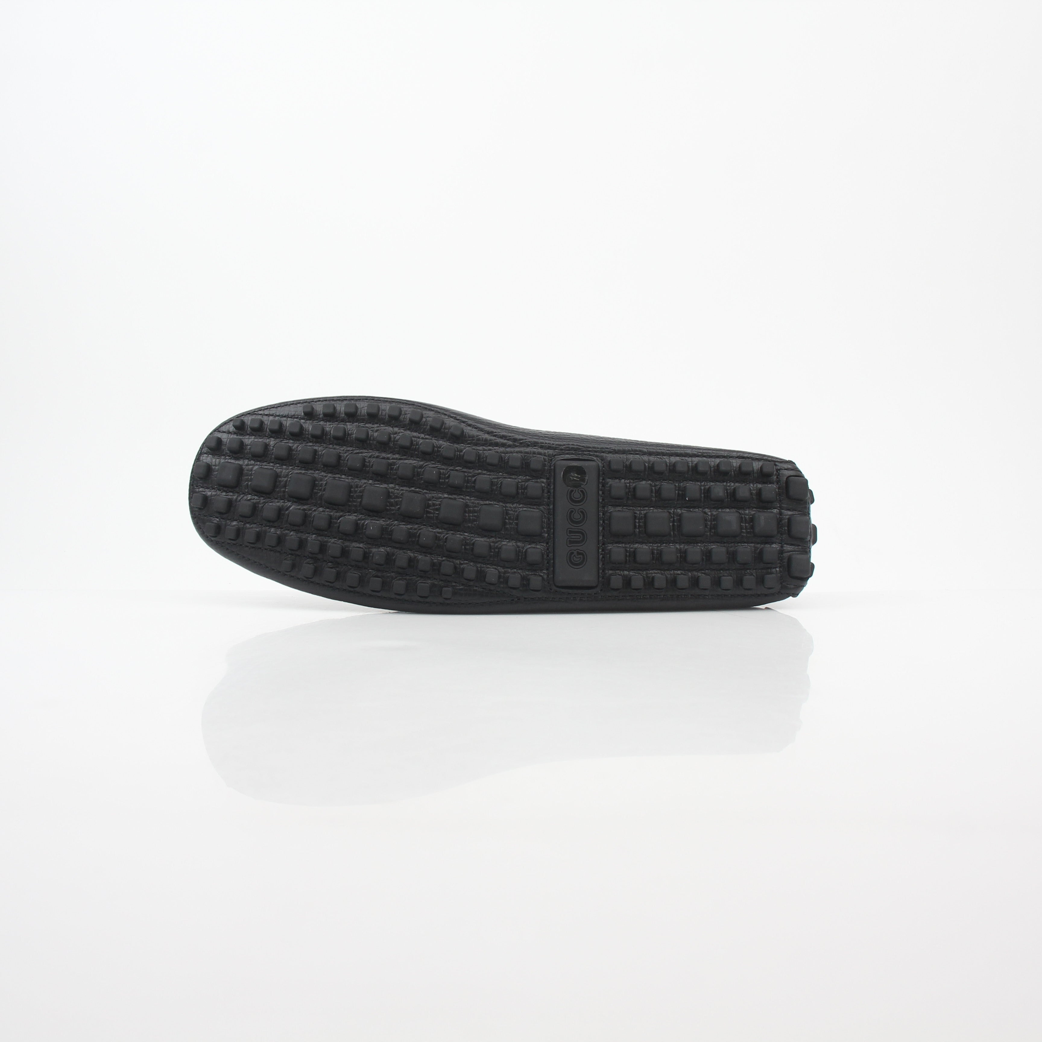 Gucci black leather Ayrton horsebit driving loafers, stylish men's shoes with gold accents, detailed stitching, and classic design.