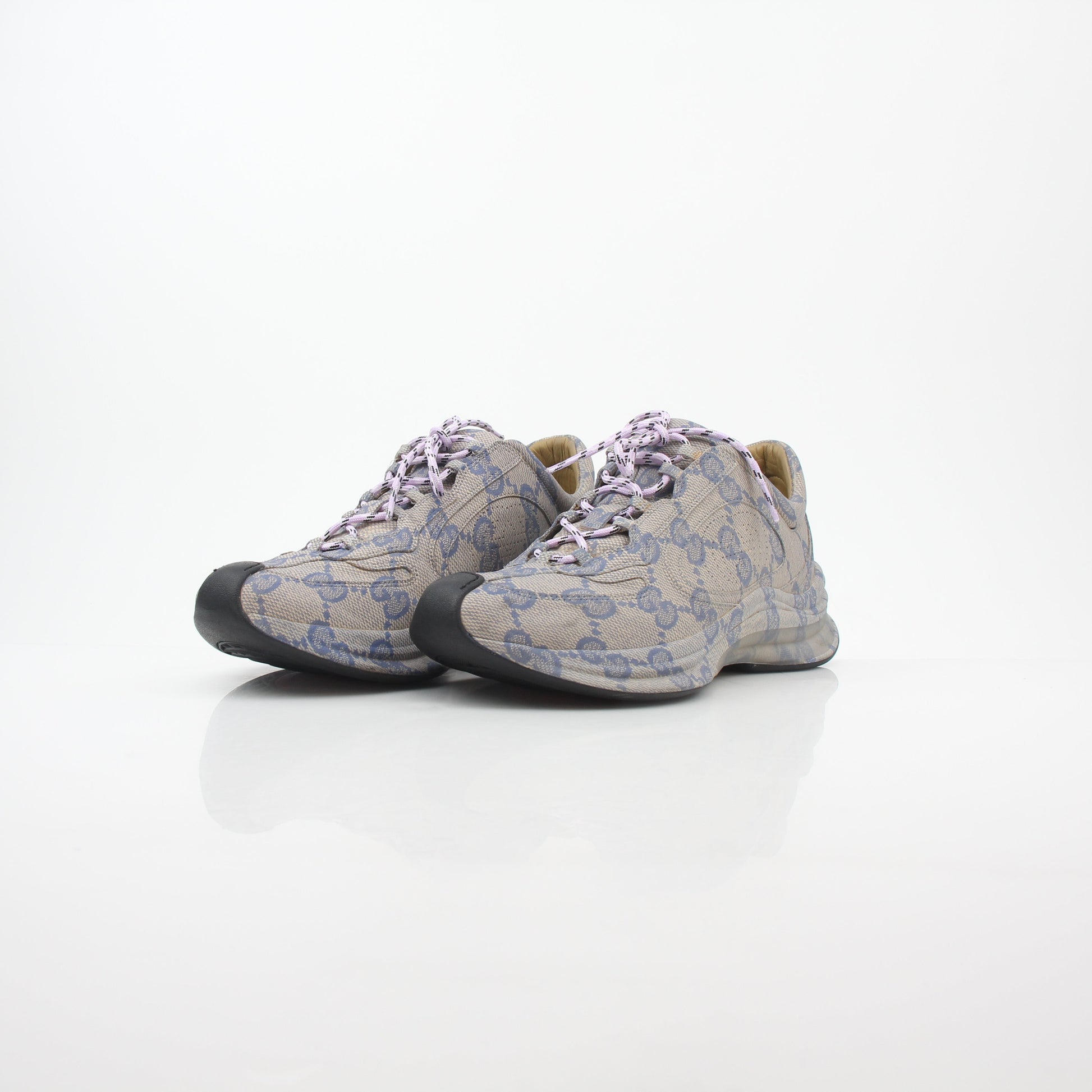 Gucci beige GG monogram Run sneakers with white soles and laces, showcasing the iconic pattern and stylish design.