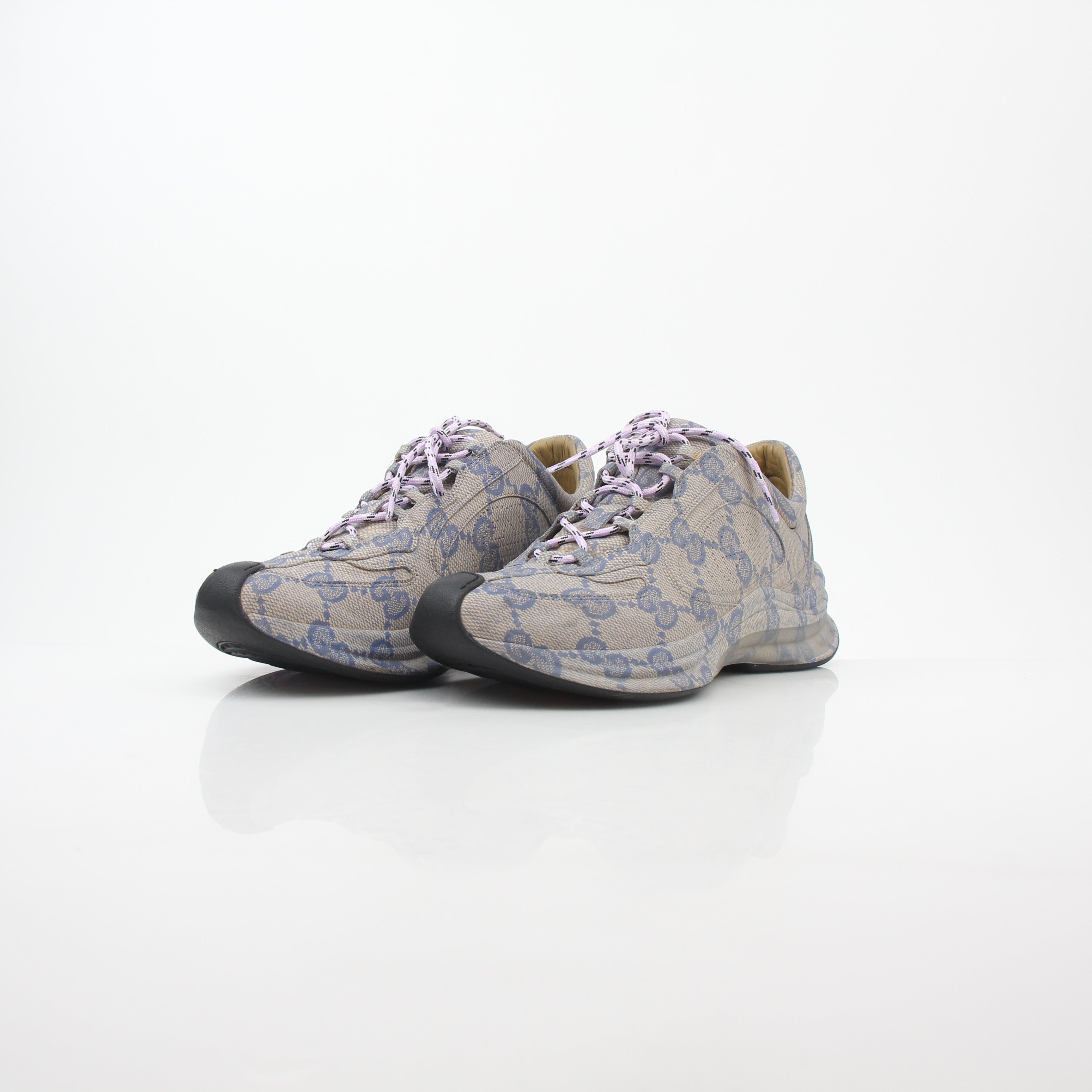 Gucci beige GG monogram Run sneakers with white soles and laces, showcasing the iconic pattern and stylish design.