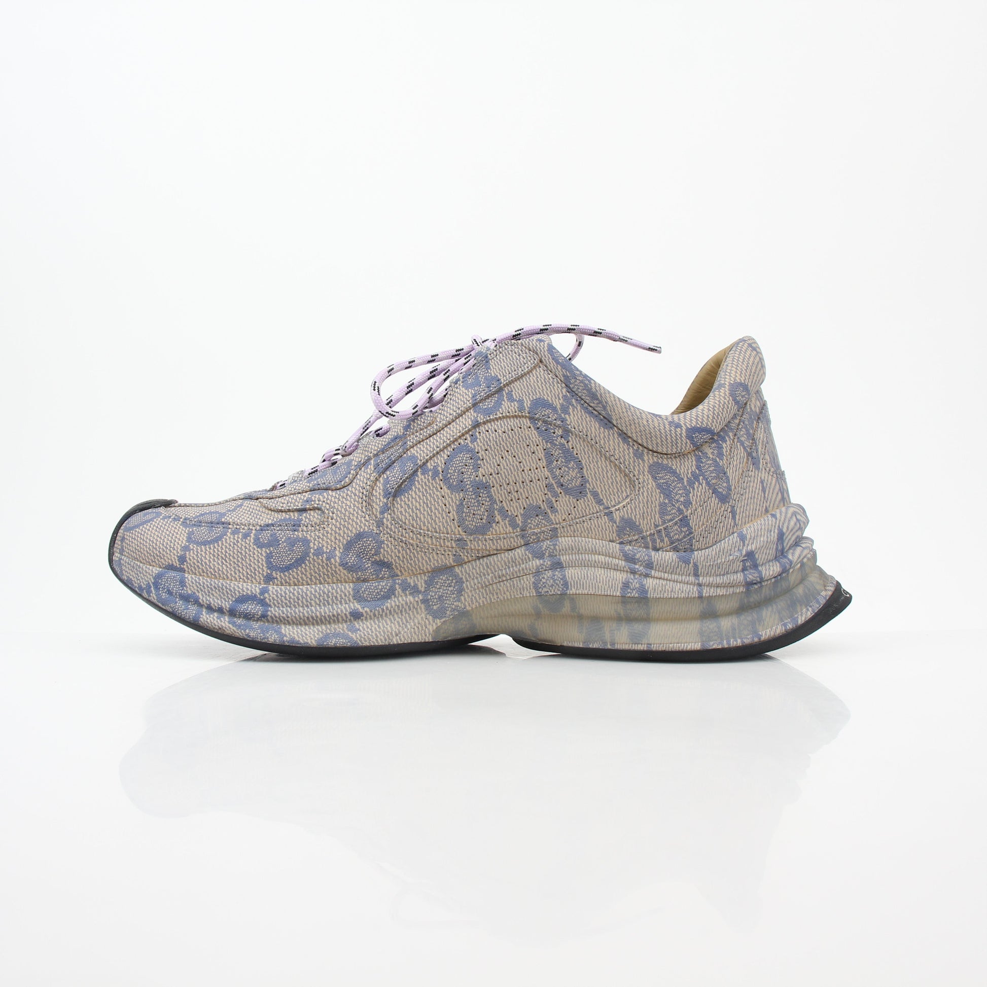 Gucci beige GG monogram Run sneakers with white soles and lace-up design, displayed on a clean background.