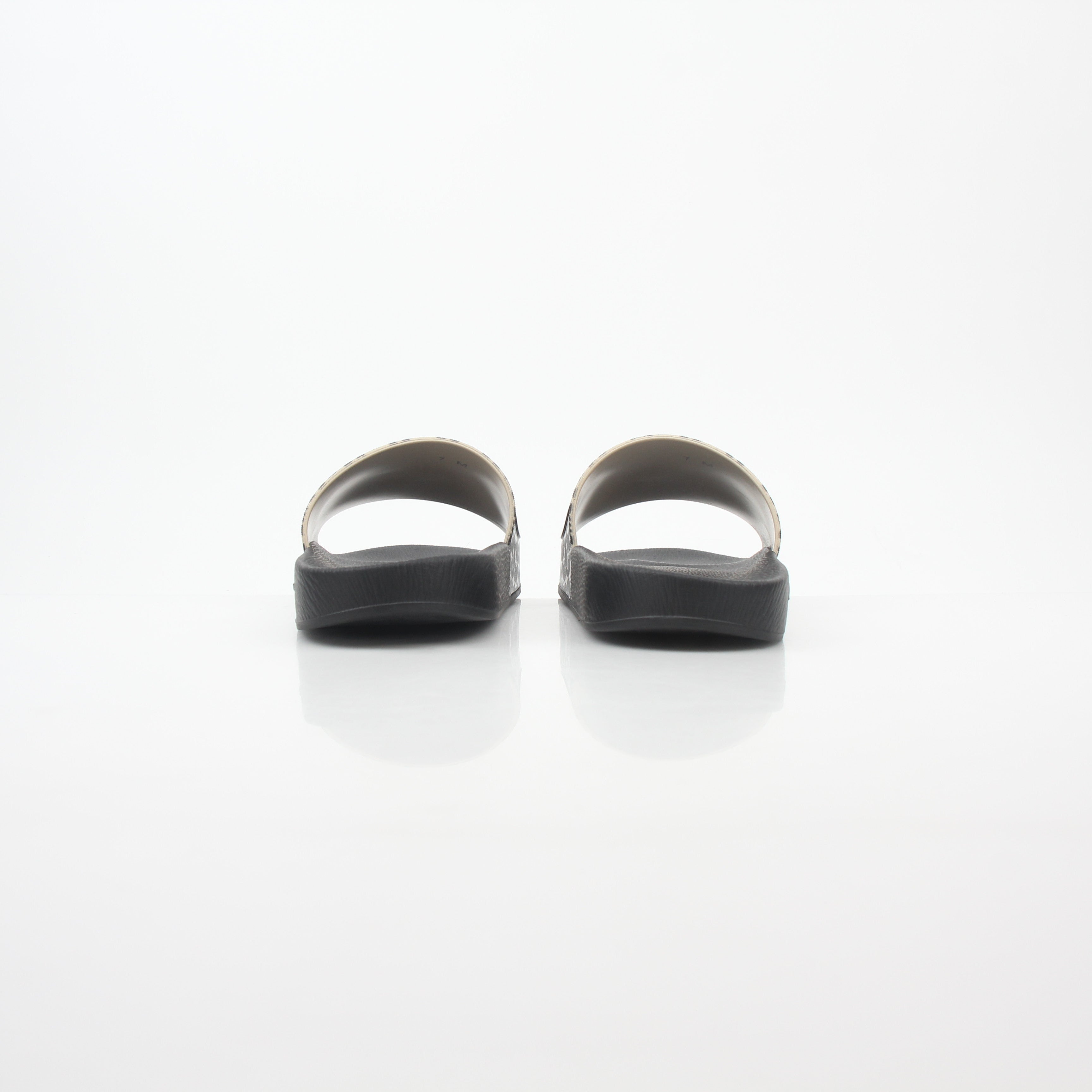 Black and beige Salvatore Ferragamo Groove 6 Gancini slide sandals with Gancini buckle design, displayed on a neutral background.