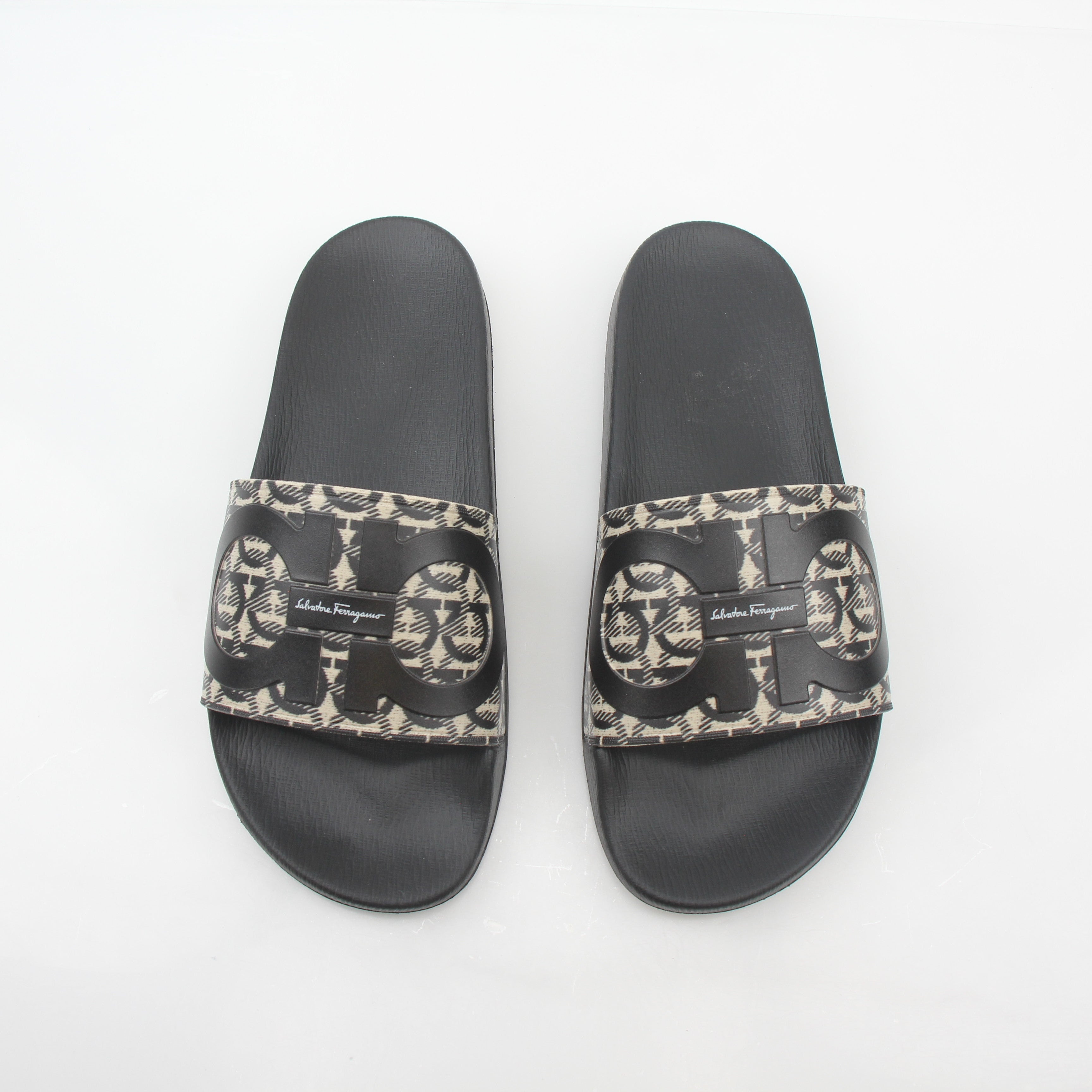 Salvatore Ferragamo black and beige Groove 6 Gancini slide sandals with open toe and slip-on design, displayed on a neutral background