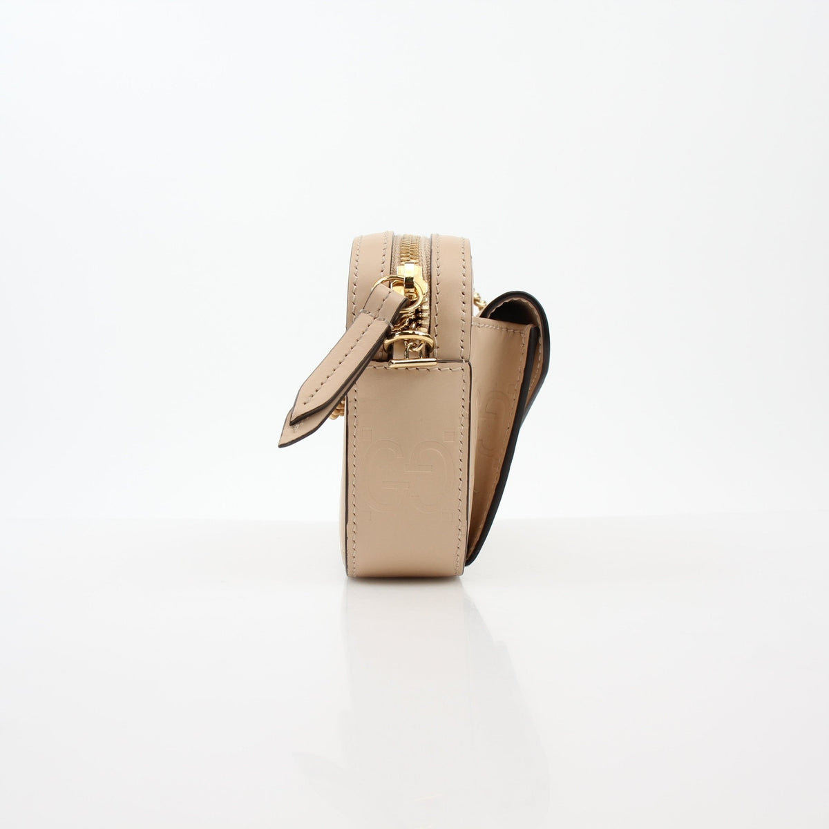 Gucci beige GG embossed Gilbert mini crossbody handbag with gold hardware and adjustable strap, stylish and compact.