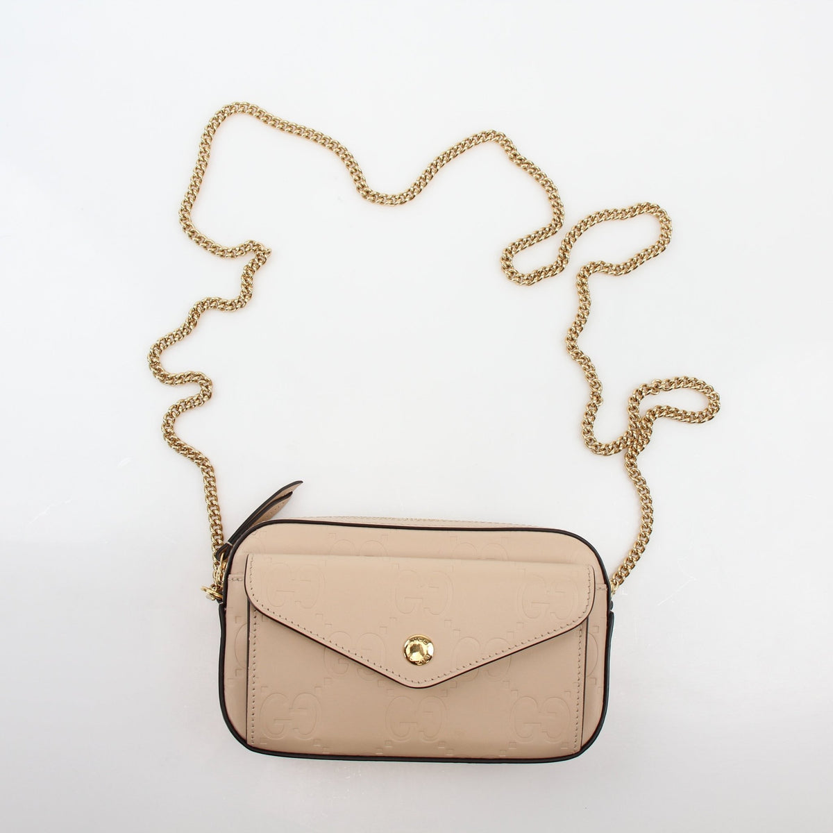 Gucci beige GG embossed Gilbert mini crossbody handbag with gold-tone hardware and adjustable strap.