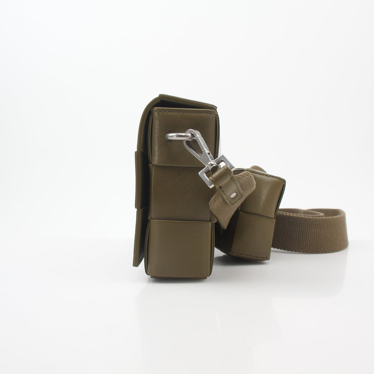 Olive green Bottega Veneta Cassette crossbody handbag with strap, featuring textured leather and gold-tone hardware.