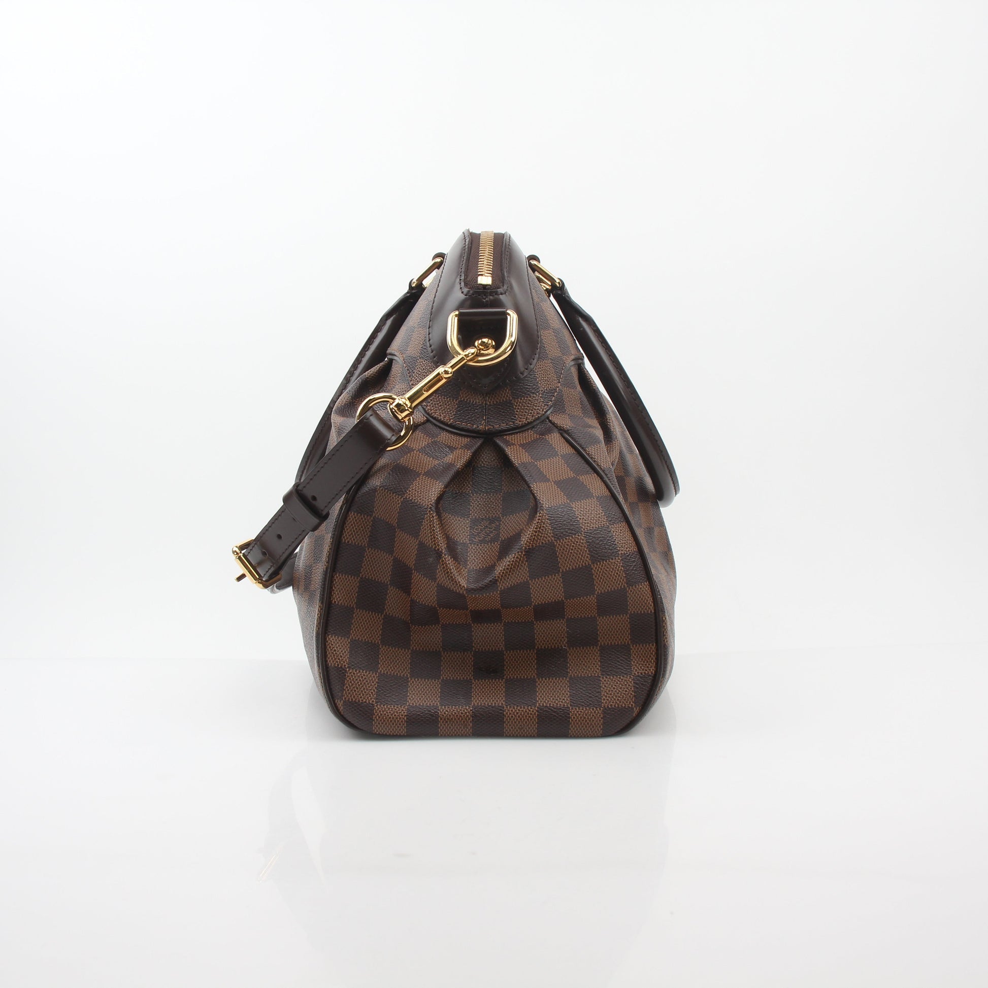 Louis Vuitton Damier Ebene Trevi GM handbag with gold hardware and leather handles, showcasing the signature checkered pattern.