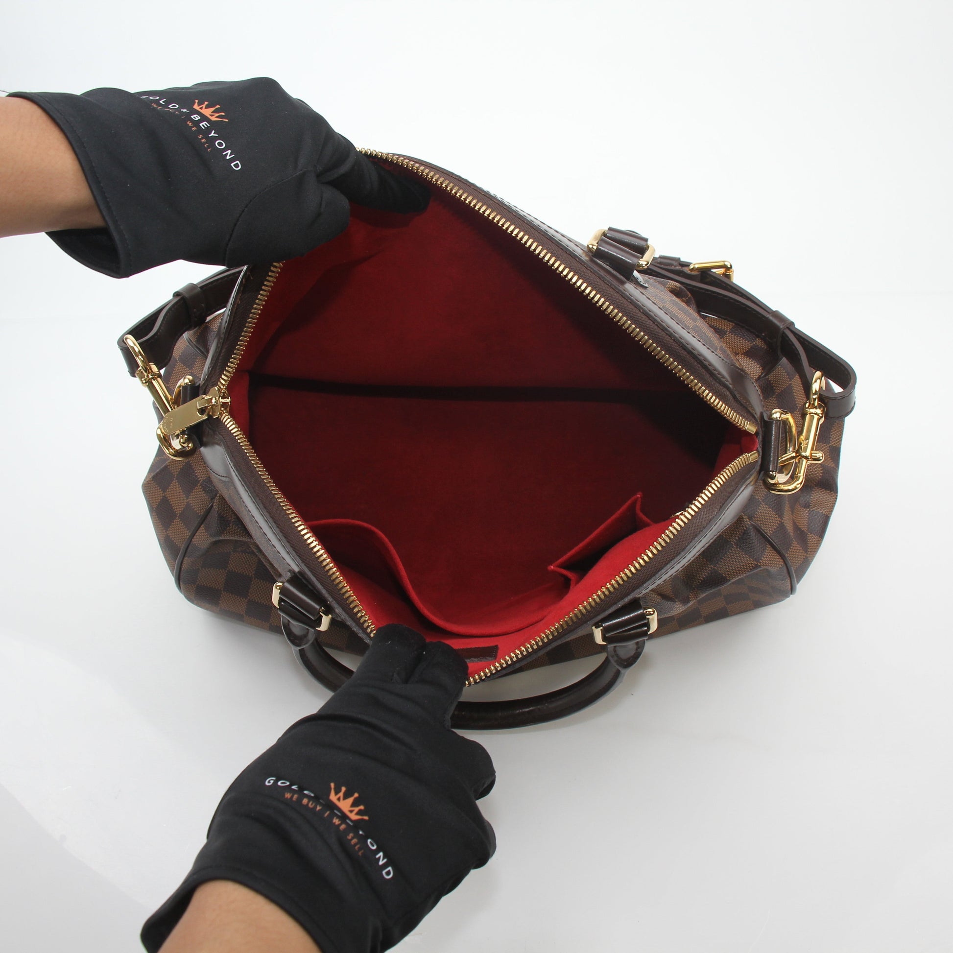 Louis Vuitton Damier Ebene Trevi GM handbag with gold hardware and leather trim, featuring the signature checkered pattern.