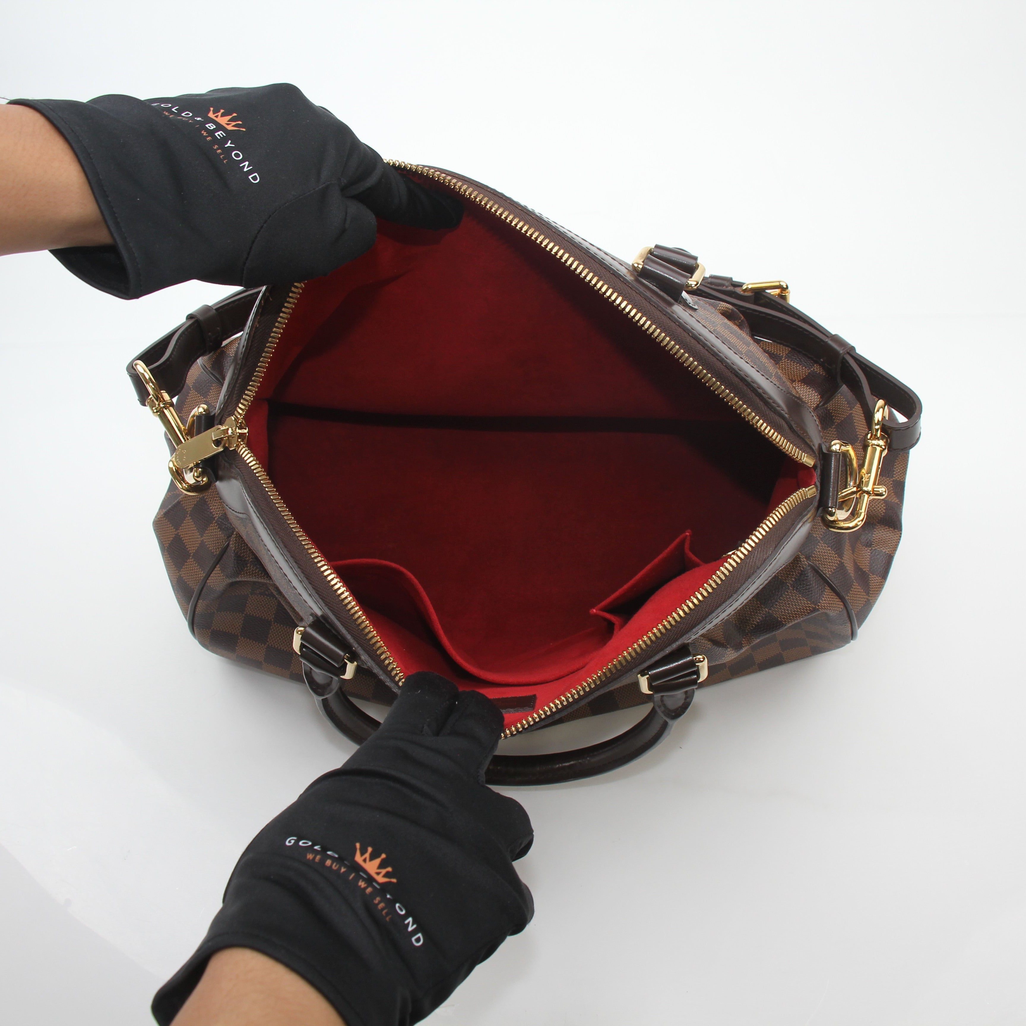 Louis Vuitton Damier Ebene Trevi GM handbag with gold hardware and leather trim, featuring the signature checkered pattern.