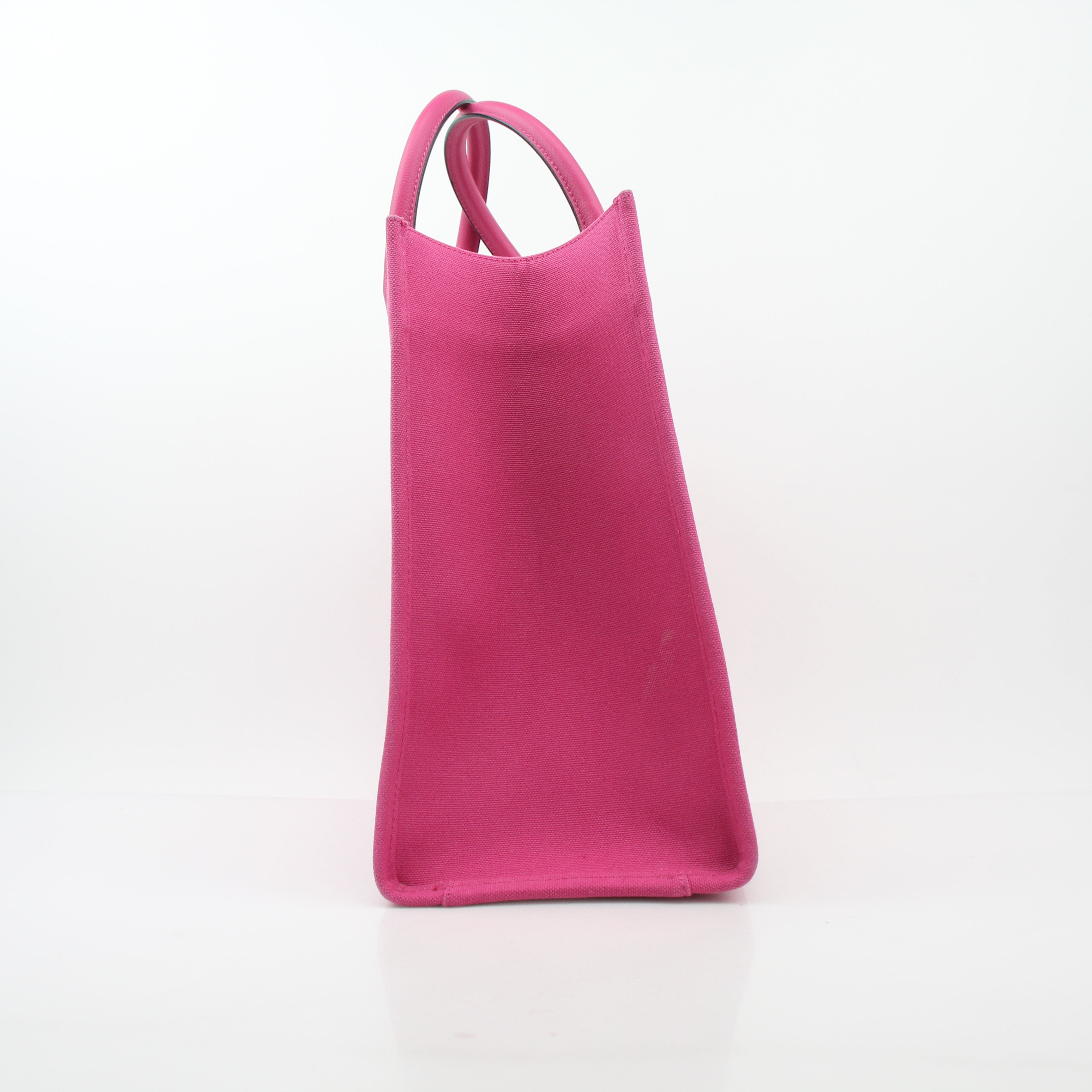 Pink Versace La Medusa embossed canvas tote bag with gold accents, stylish handbag with bold branding and spacious interior.