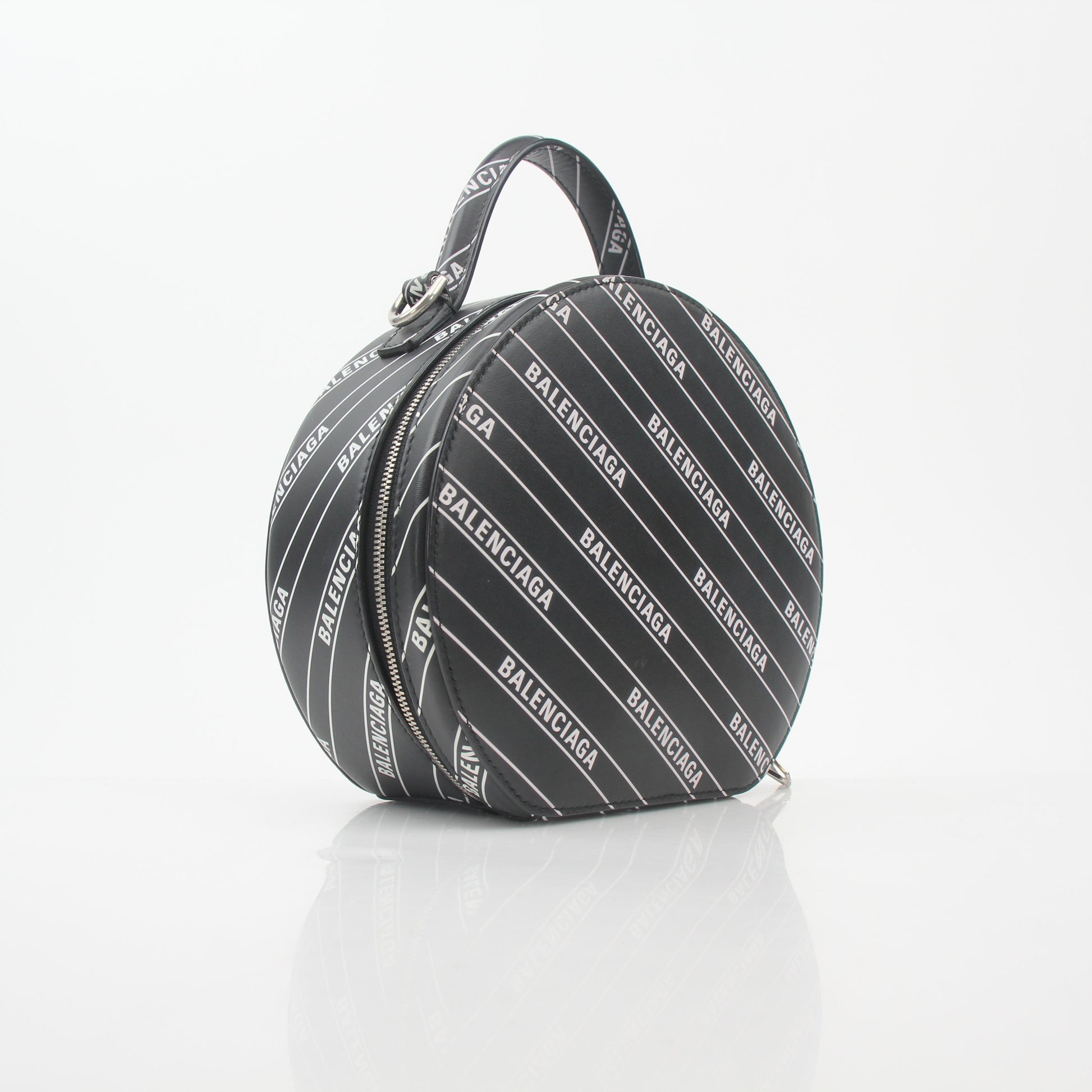Black Balenciaga logo XS Vanity round handbag with gold accents, featuring a compact, stylish design on a white background.