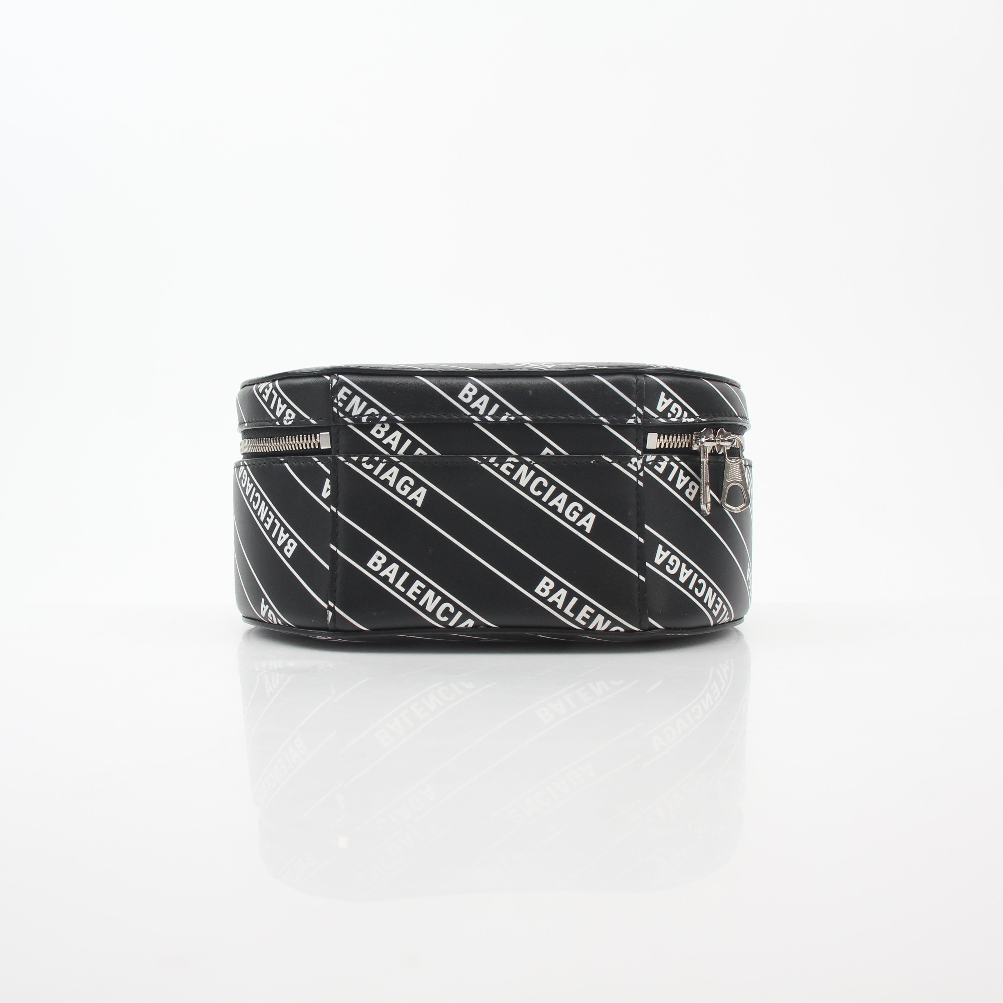 Black Balenciaga XS Vanity round handbag with logo design, featuring a compact, stylish leather purse with gold accents.
