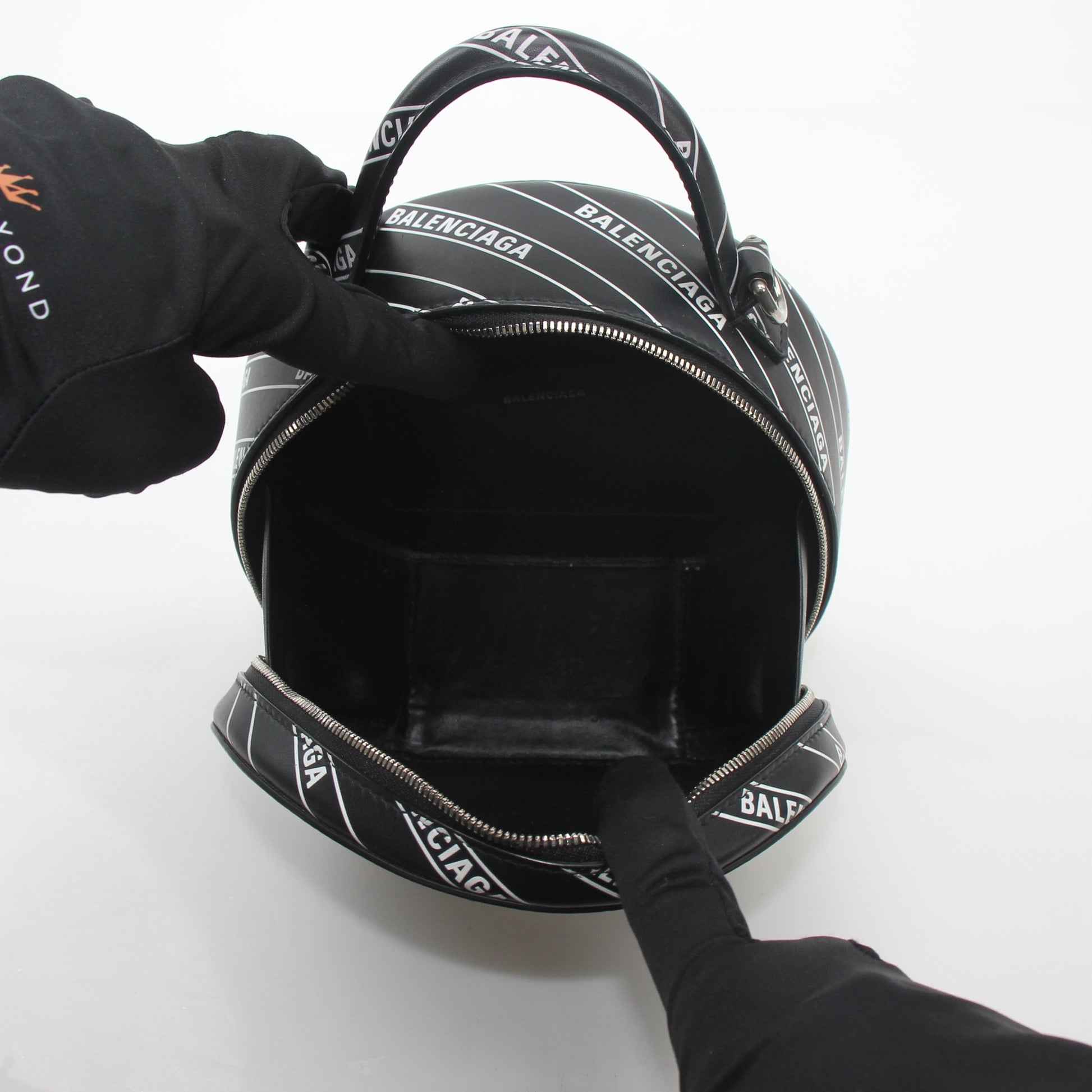 Black Balenciaga XS Vanity round handbag with logo, featuring a compact, stylish design and gold hardware details.