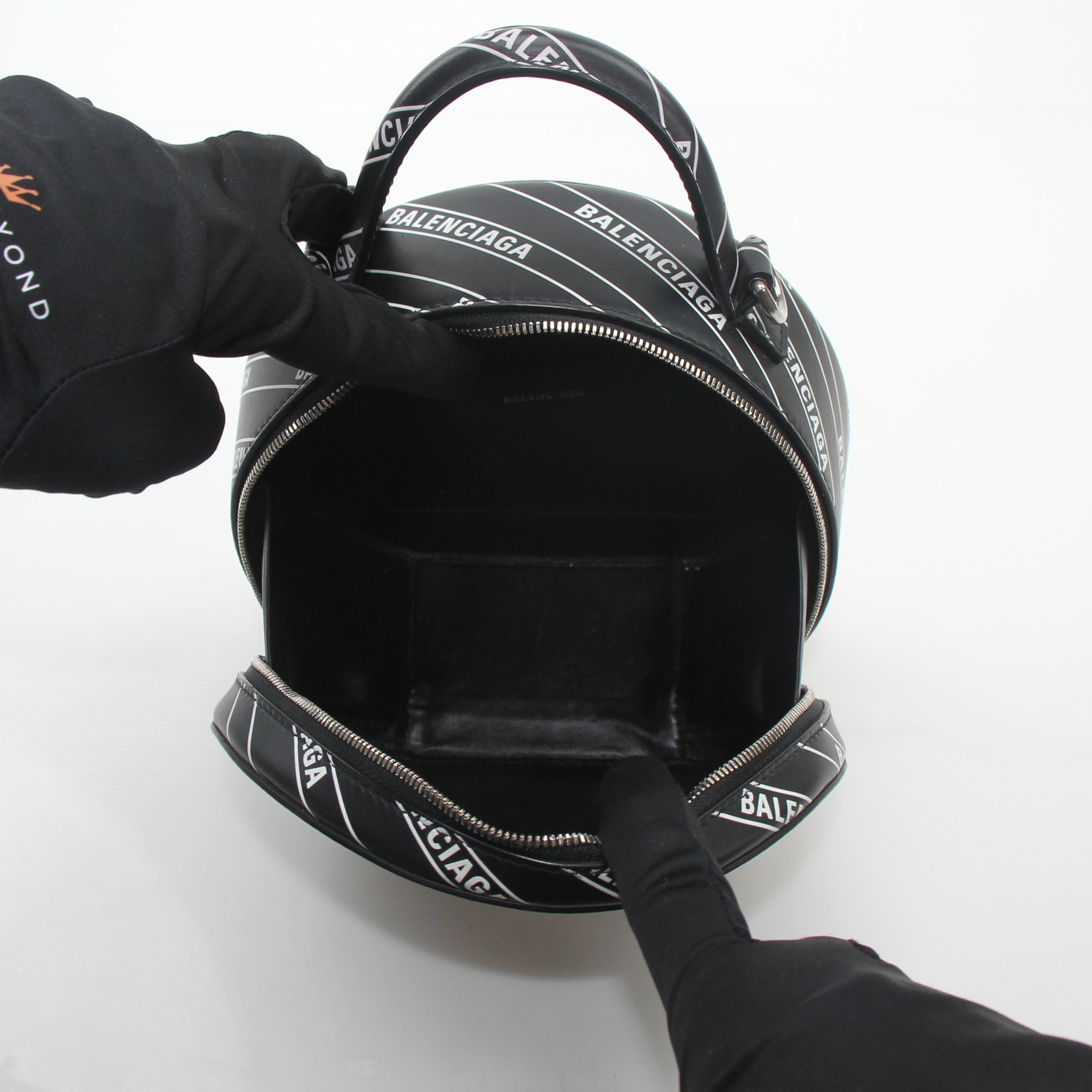 Black Balenciaga XS Vanity round handbag with logo, featuring a compact, stylish design and gold hardware details.