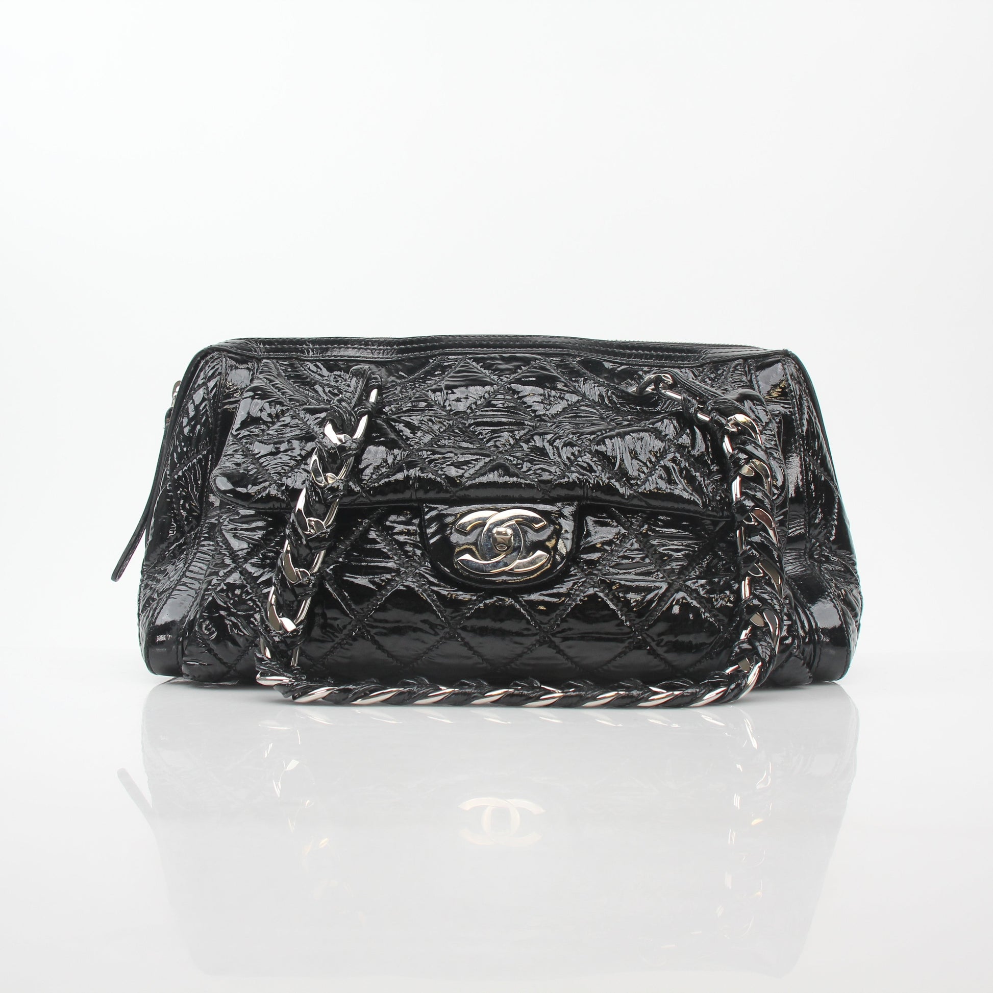 Black quilted patent Chanel Day Glossy Flap Handbag with gold chain strap and signature logo detailing.