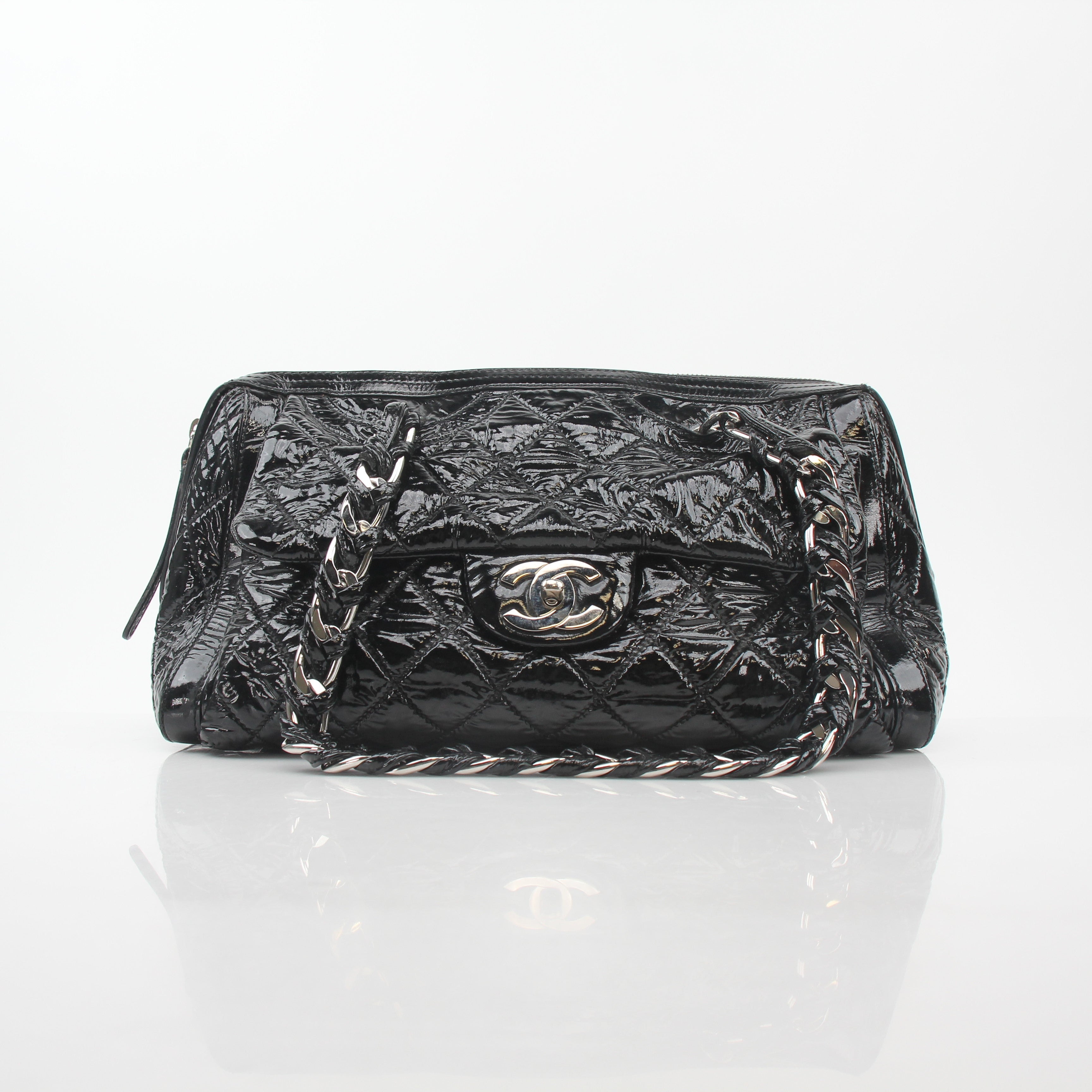 Black quilted patent Chanel Day Glossy Flap Handbag with gold chain strap and signature logo detailing.