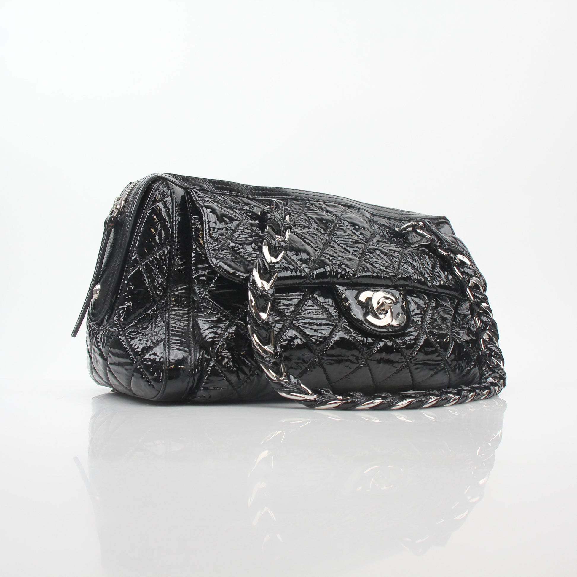 Chanel black quilted patent Day Glossy Flap Bag with gold hardware, classic handbag design, and quilted pattern.