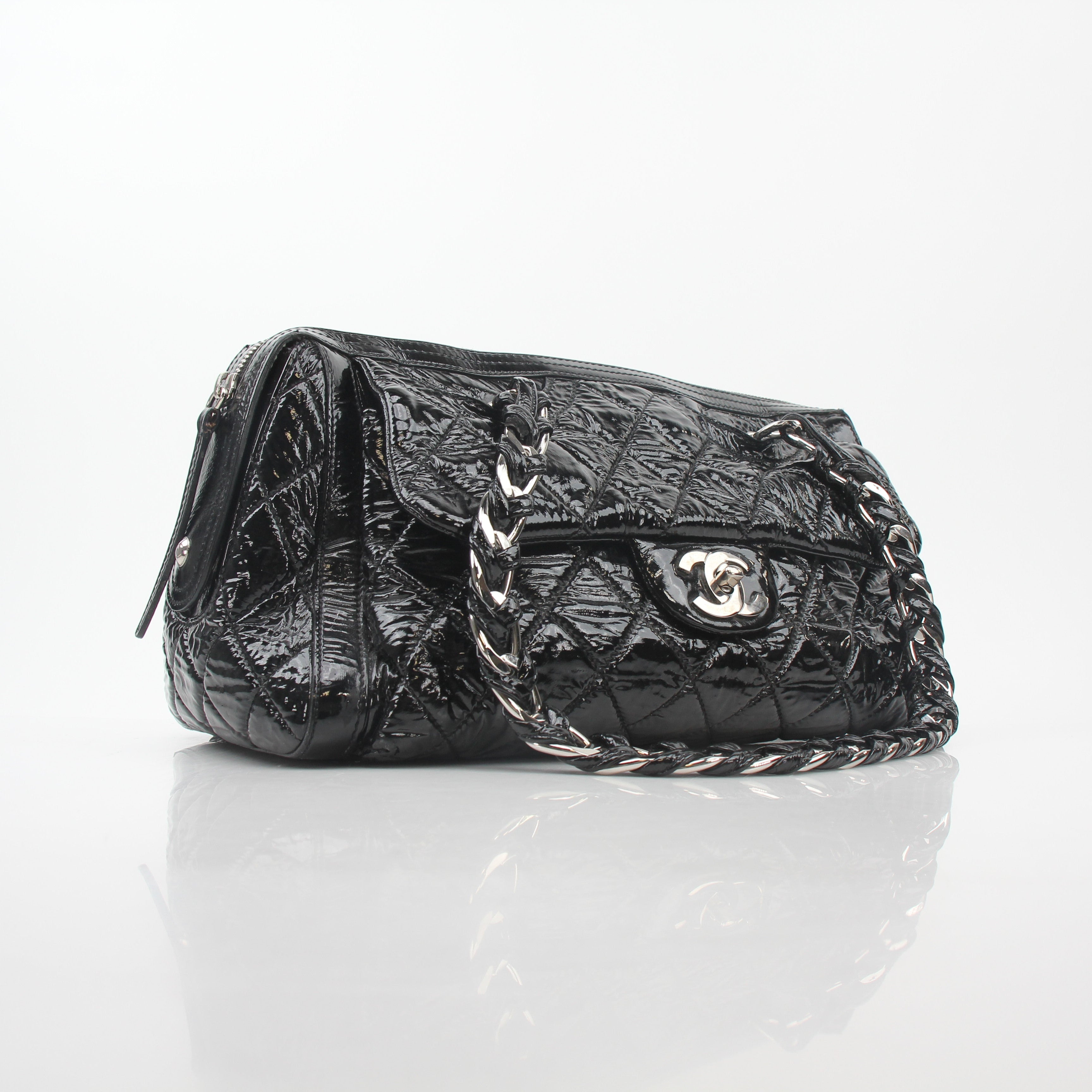 Chanel black quilted patent Day Glossy Flap Bag with gold hardware, classic handbag design, and quilted pattern.