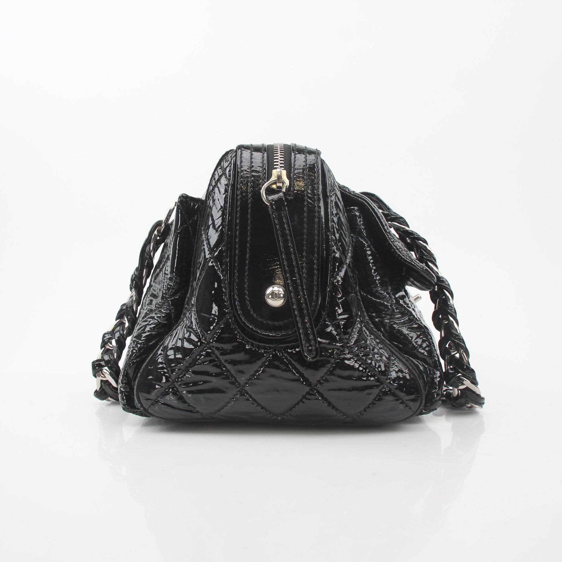 Black quilted patent Chanel handbag with glossy finish and gold hardware, featuring a flap closure and chain strap.