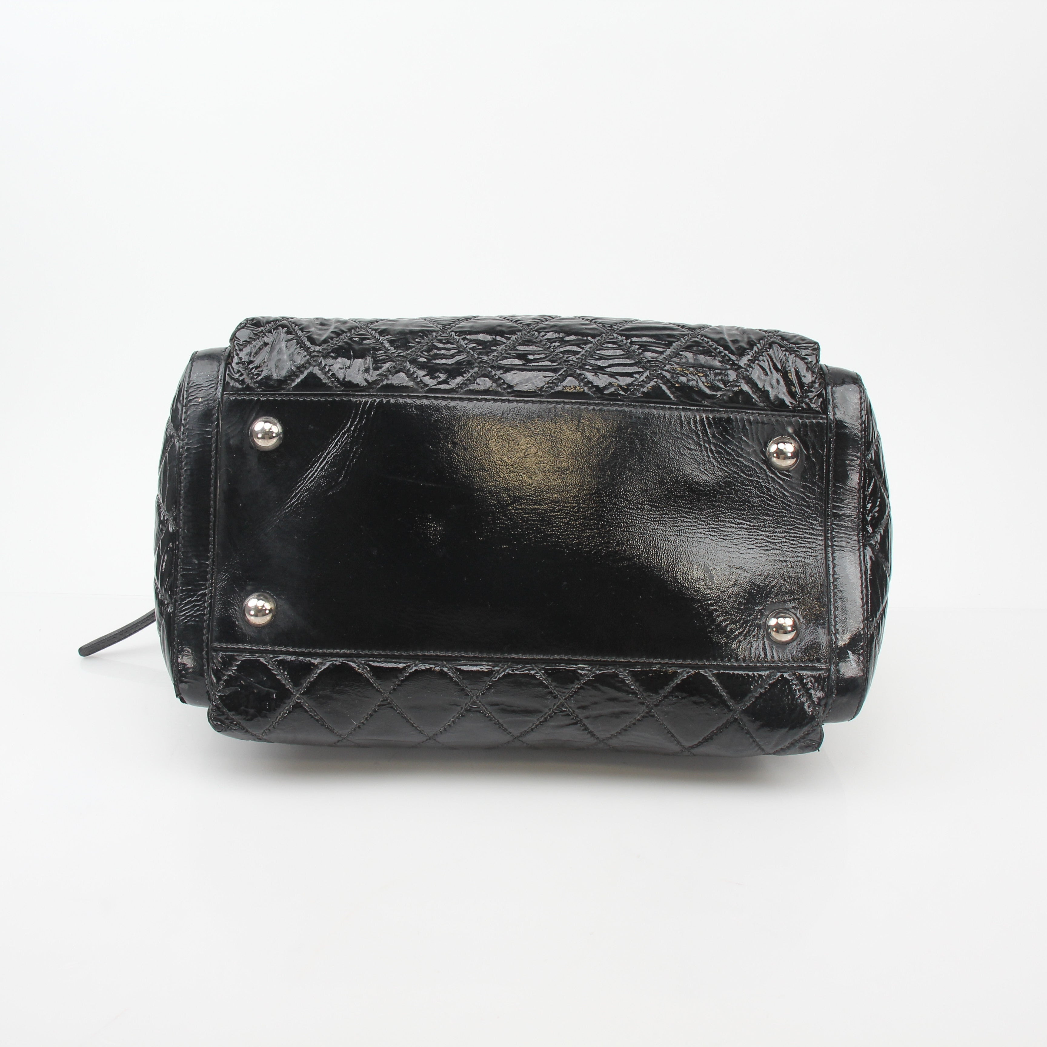 Gold & Beyond black quilted patent handbag with glossy flap and gold chain strap, stylish and elegant accessory.
