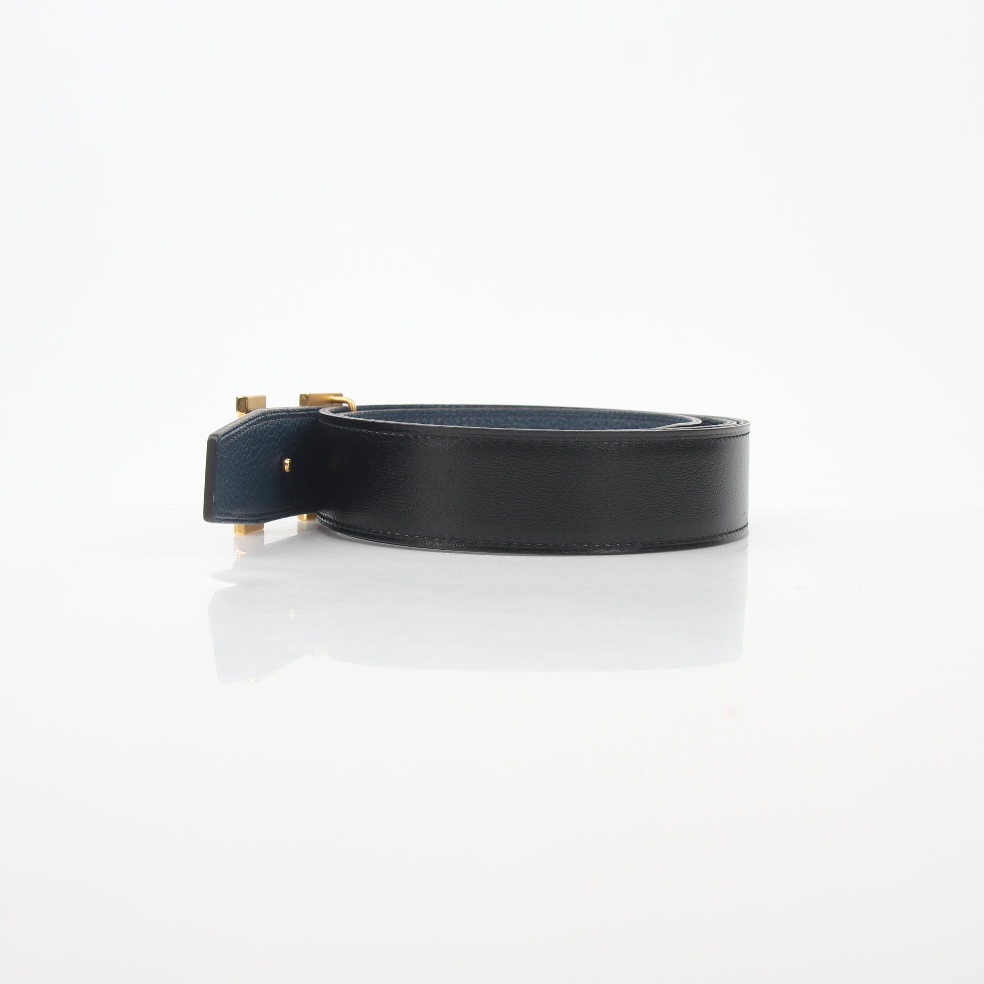 Hermès black and blue reversible belt kit with H logo, showcasing the adjustable strap and stylish accessories.