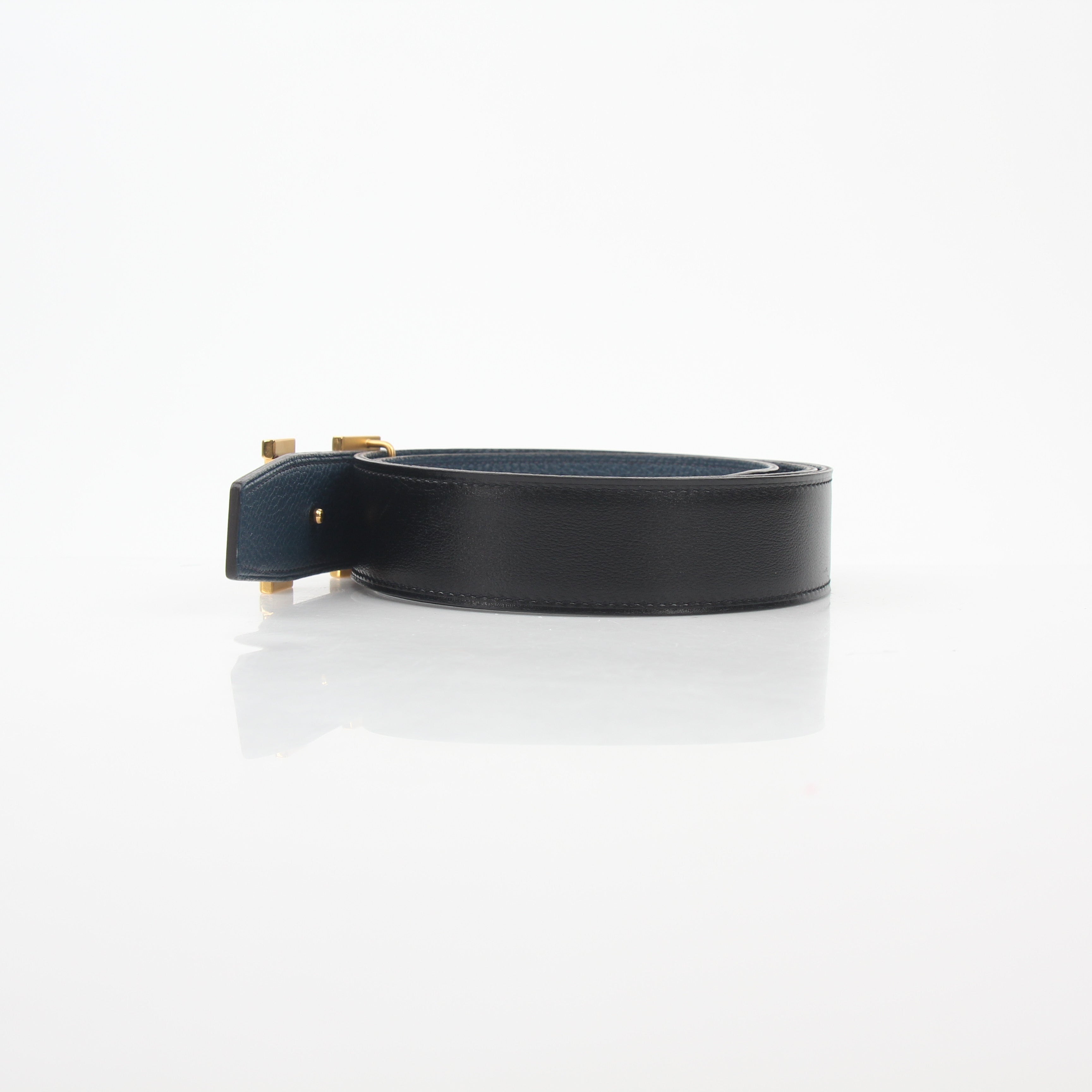 Hermès black and blue reversible belt kit with H logo, showcasing the adjustable strap and stylish accessories.