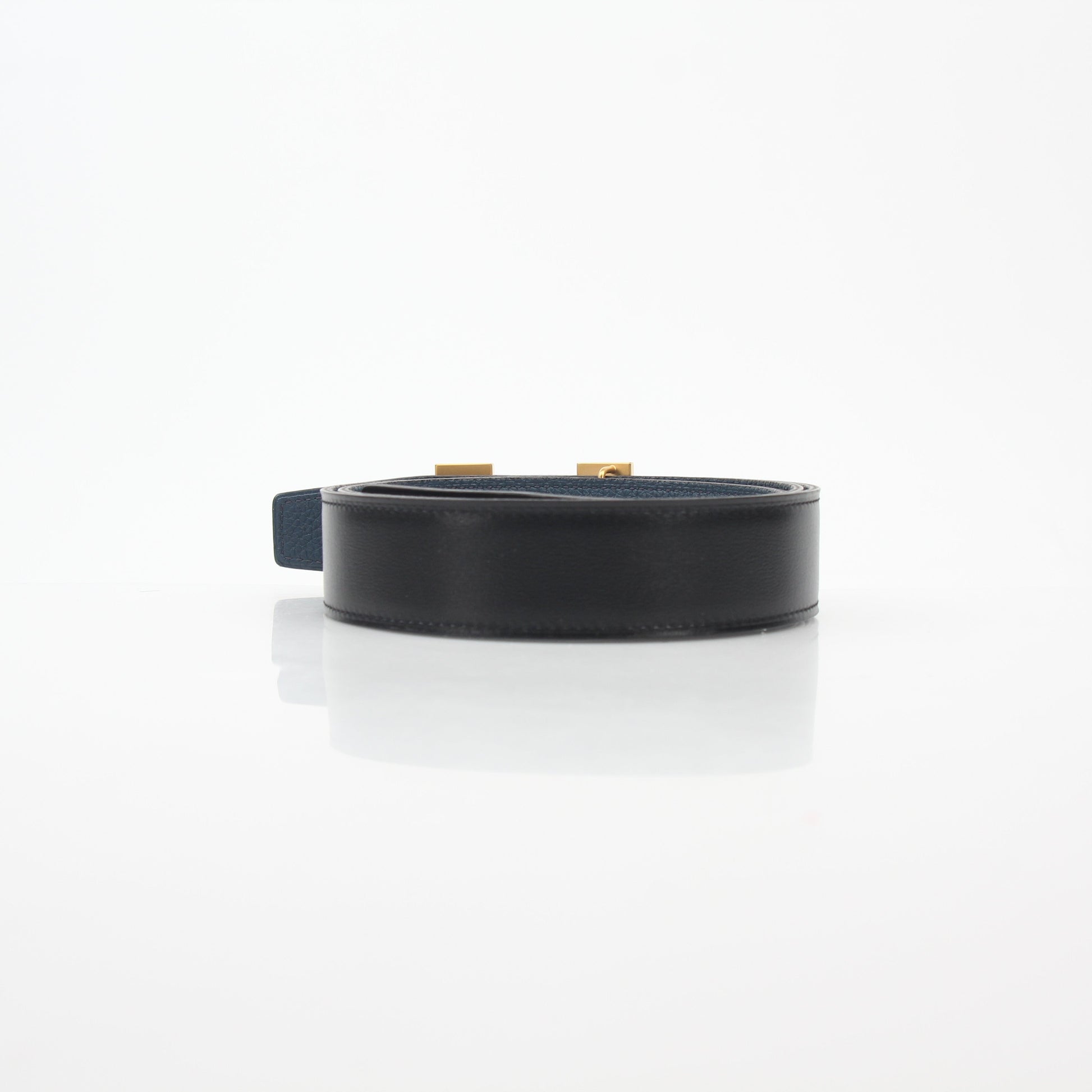 Hermès black and blue reversible belt by Gold & Beyond, showing the H buckle and adjustable strap details.