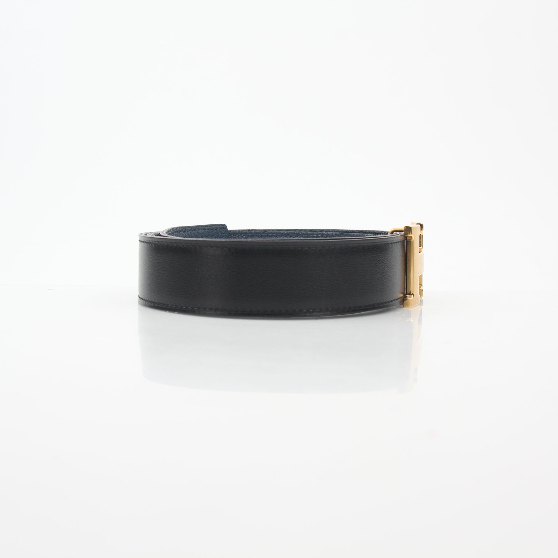 Hermès black and blue reversible belt kit with H buckle, featuring leather straps and metal hardware, designed for stylish accessories.
