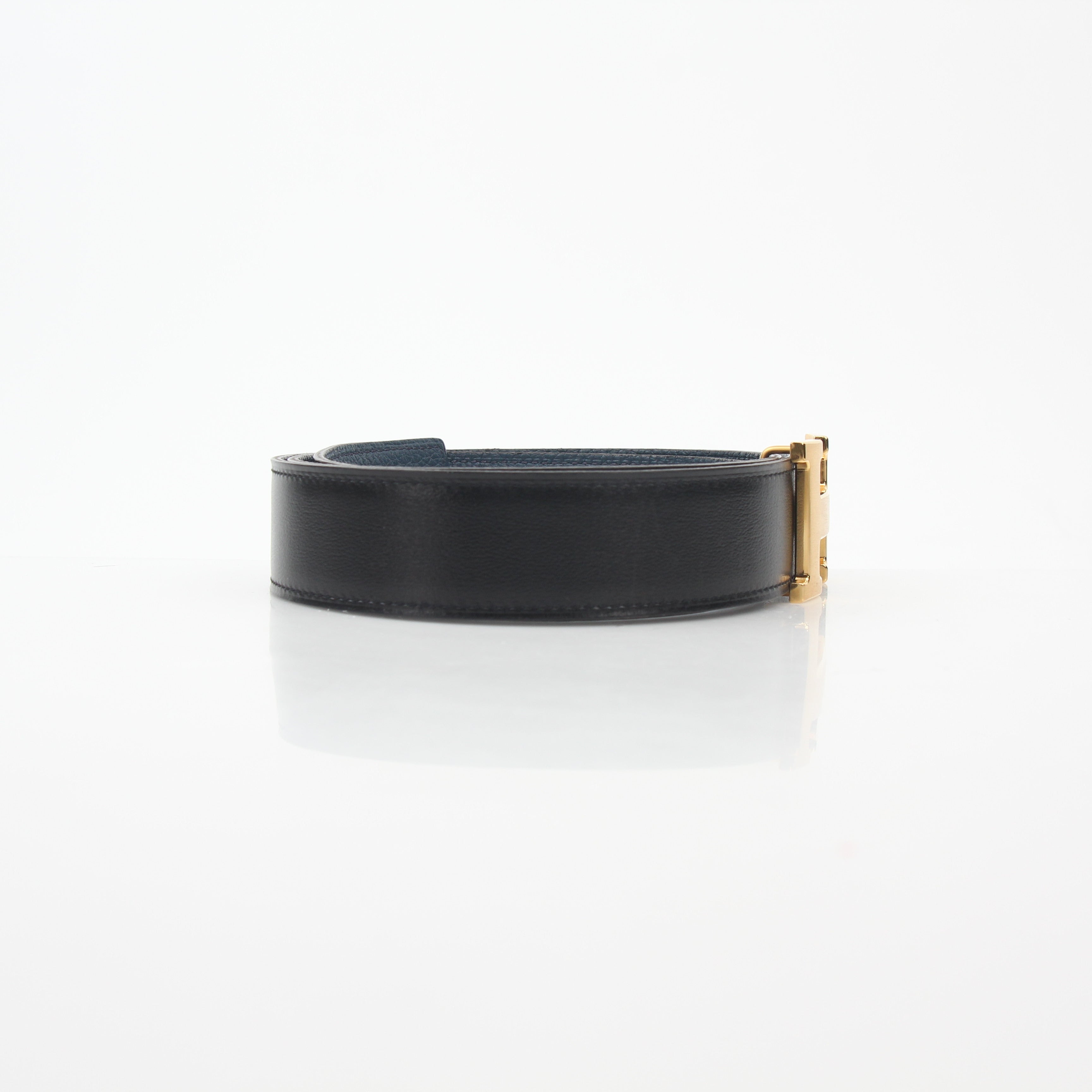 Hermès black and blue reversible belt kit with H buckle, featuring leather straps and metal hardware, designed for stylish accessories.