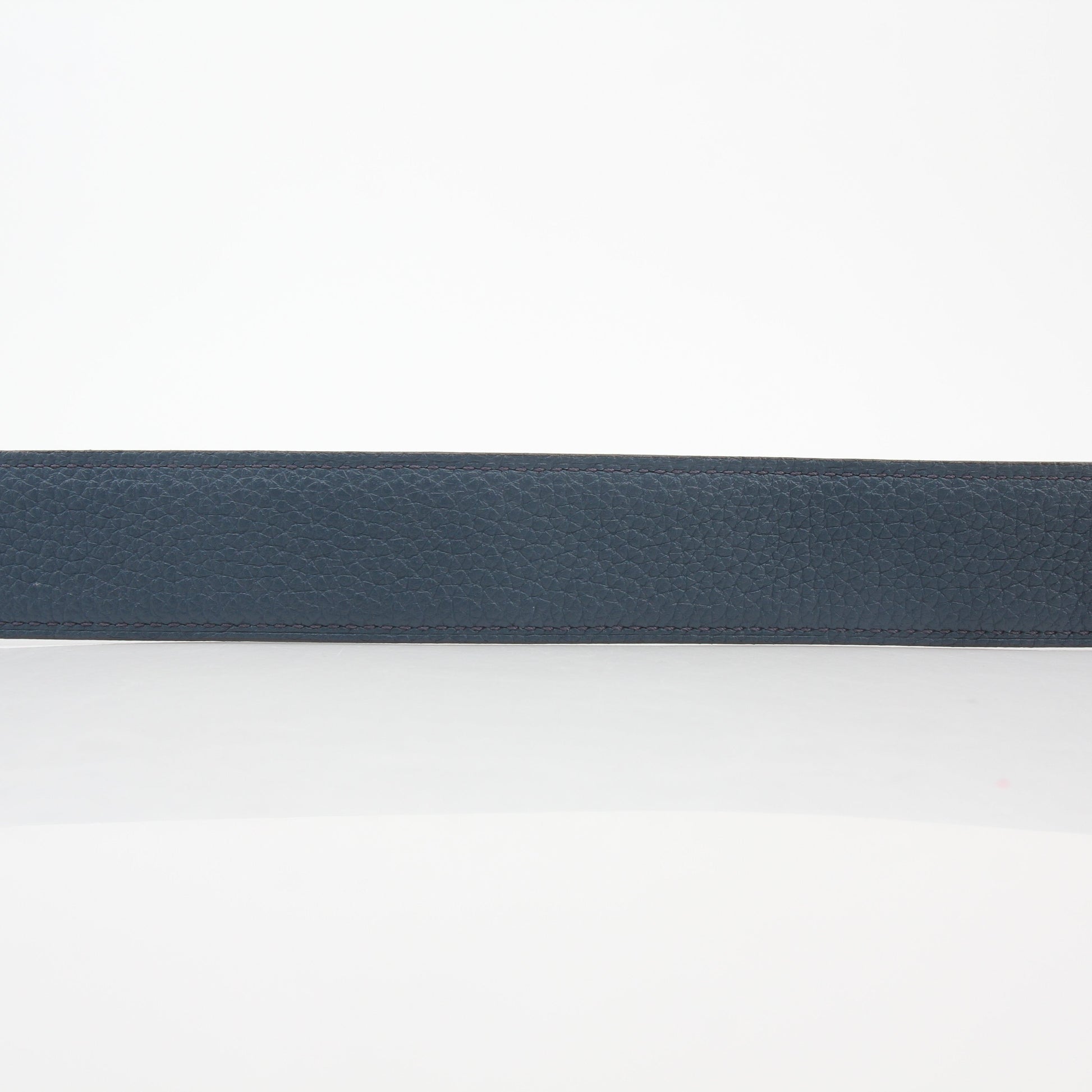 Hermès black and blue reversible belt by Gold & Beyond, showing the H buckle and reversible strap in a close-up image.