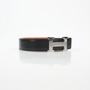 Hermès black and orange H reversible belt kit with gold accents, showcasing the stylish accessory and versatile design.