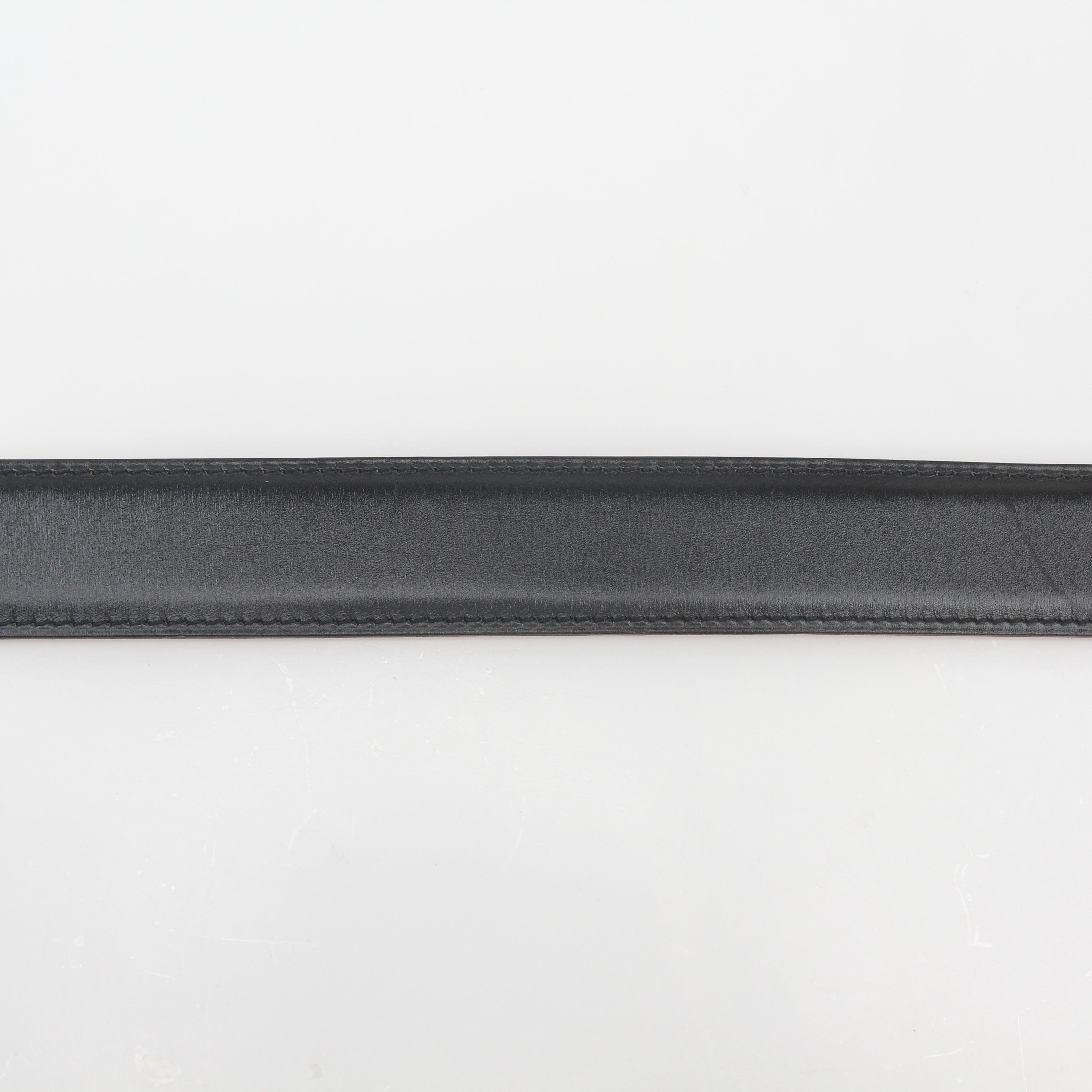 Hermès black and orange H reversible belt kit with gold accents, featuring adjustable straps and classic design.