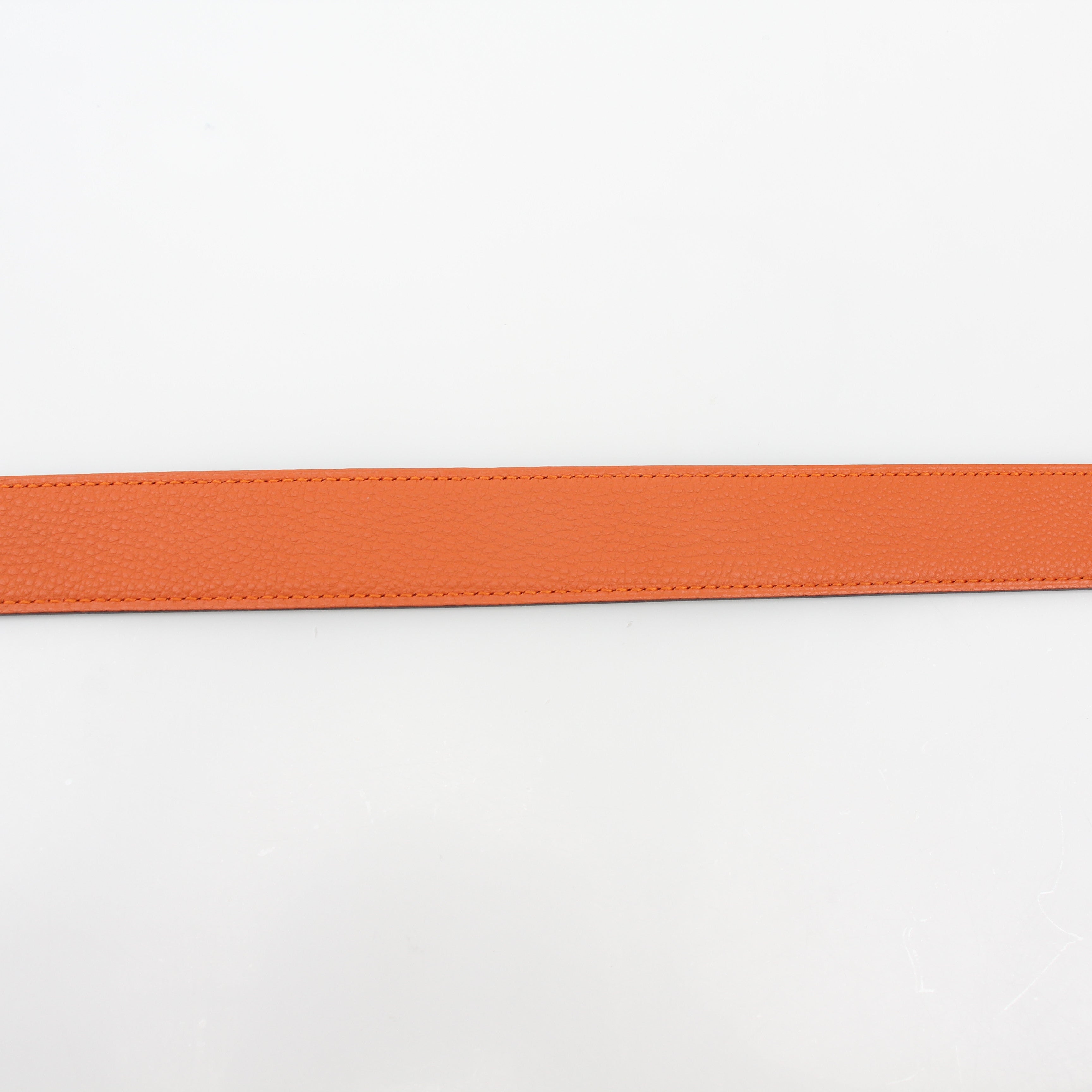 Hermès black and orange reversible belt kit by Gold & Beyond, showing the stylish belt with reversible H buckle and accessories.