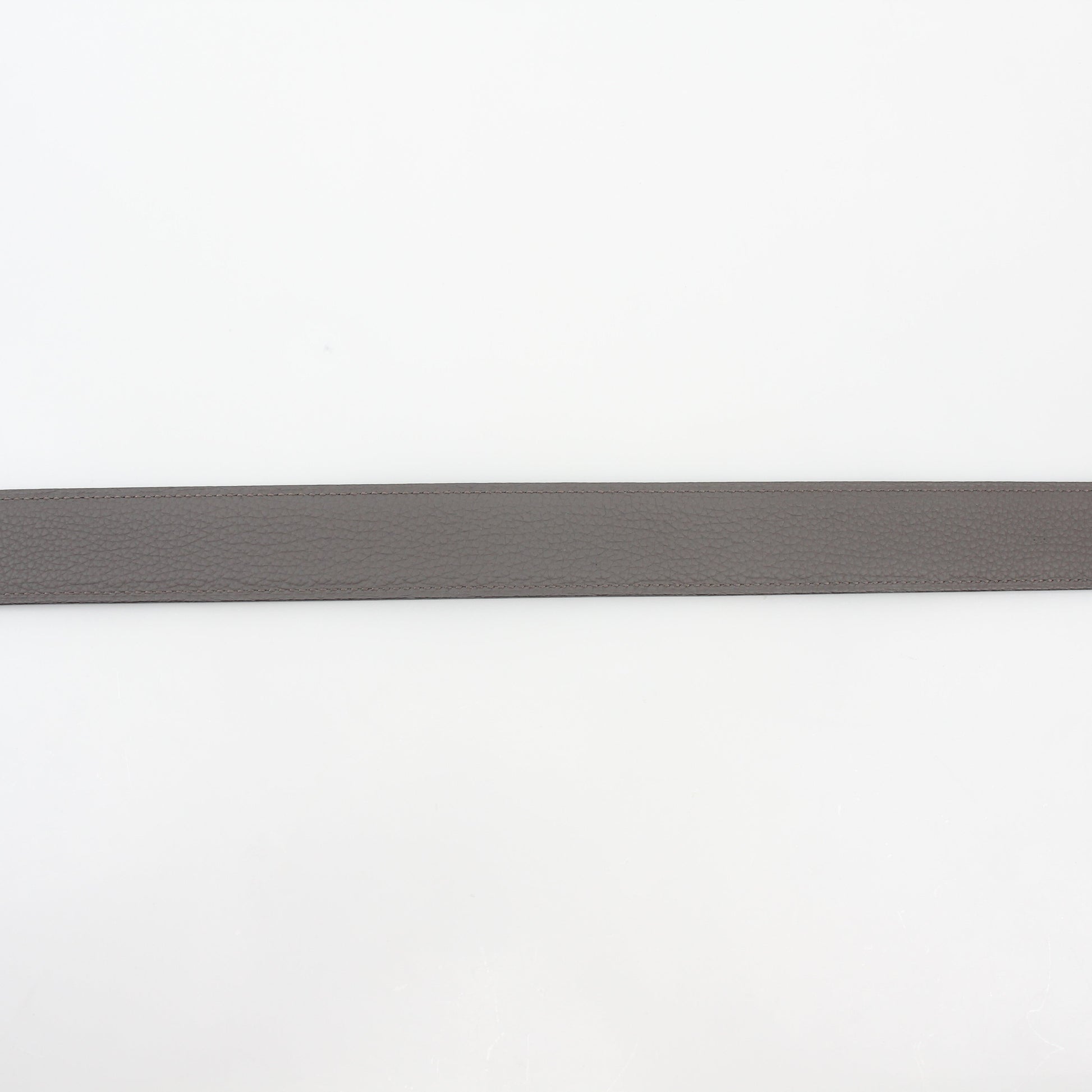 Hermès black and etoupe reversible leather belt strap with gold hardware, designed for accessories and versatile styling.