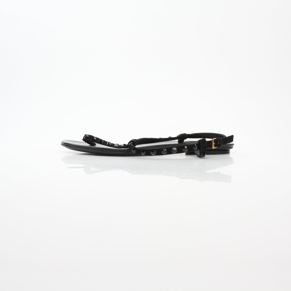 Gucci black crystal-embellished T-strap flat sandals with sleek design and buckle closure, displayed on a white background.